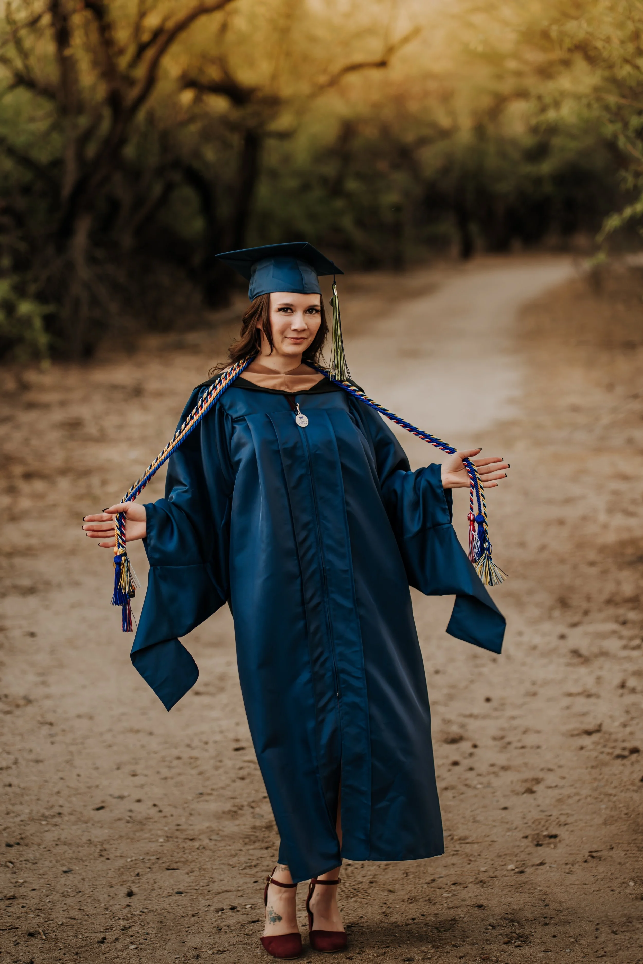 A woman poses for her graduation photoshoot outdoors in Tucson, Arizona.