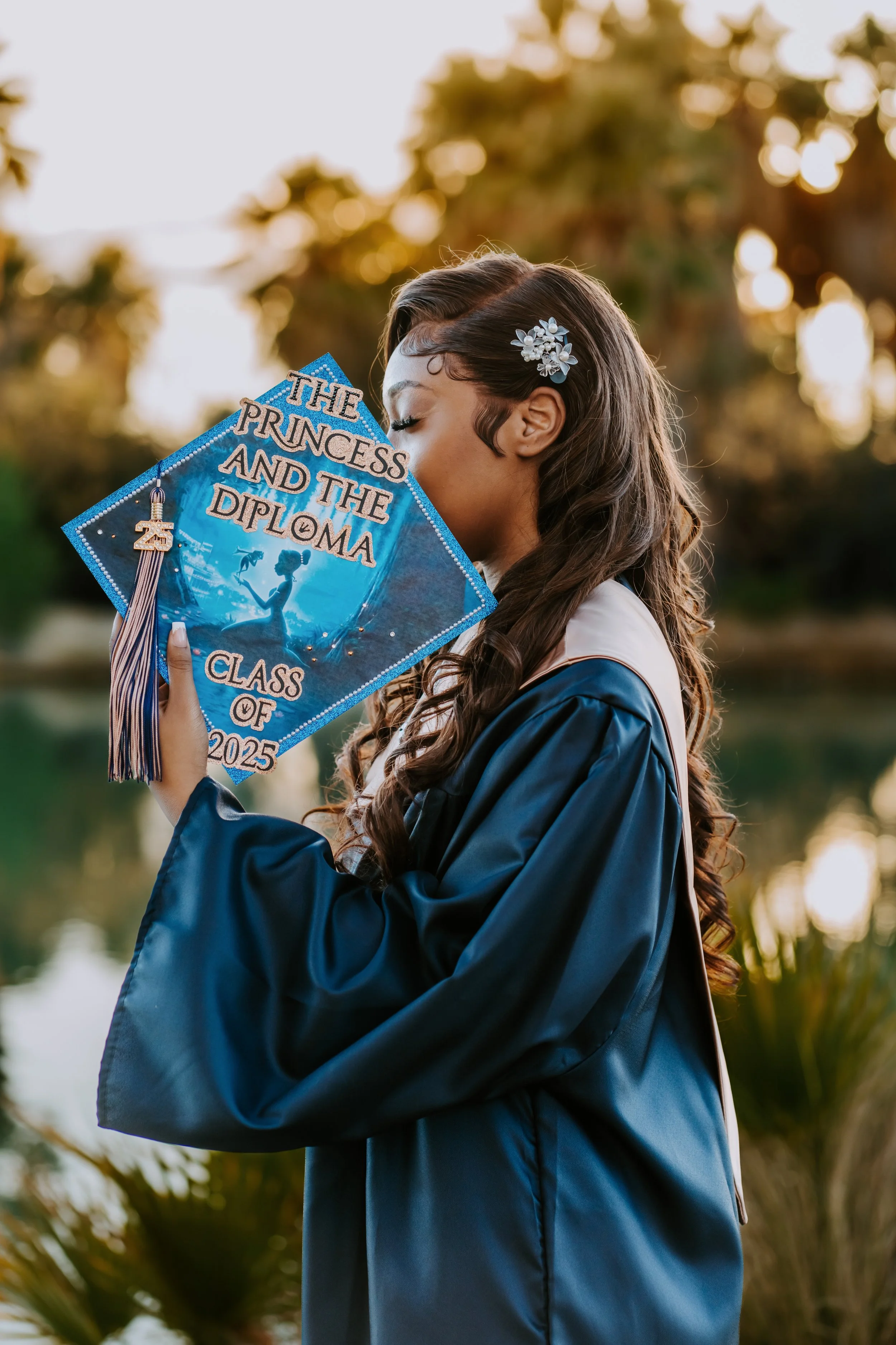 A graduate holds her cap to her face in a sunset photoshoot in Tucson Arizona.