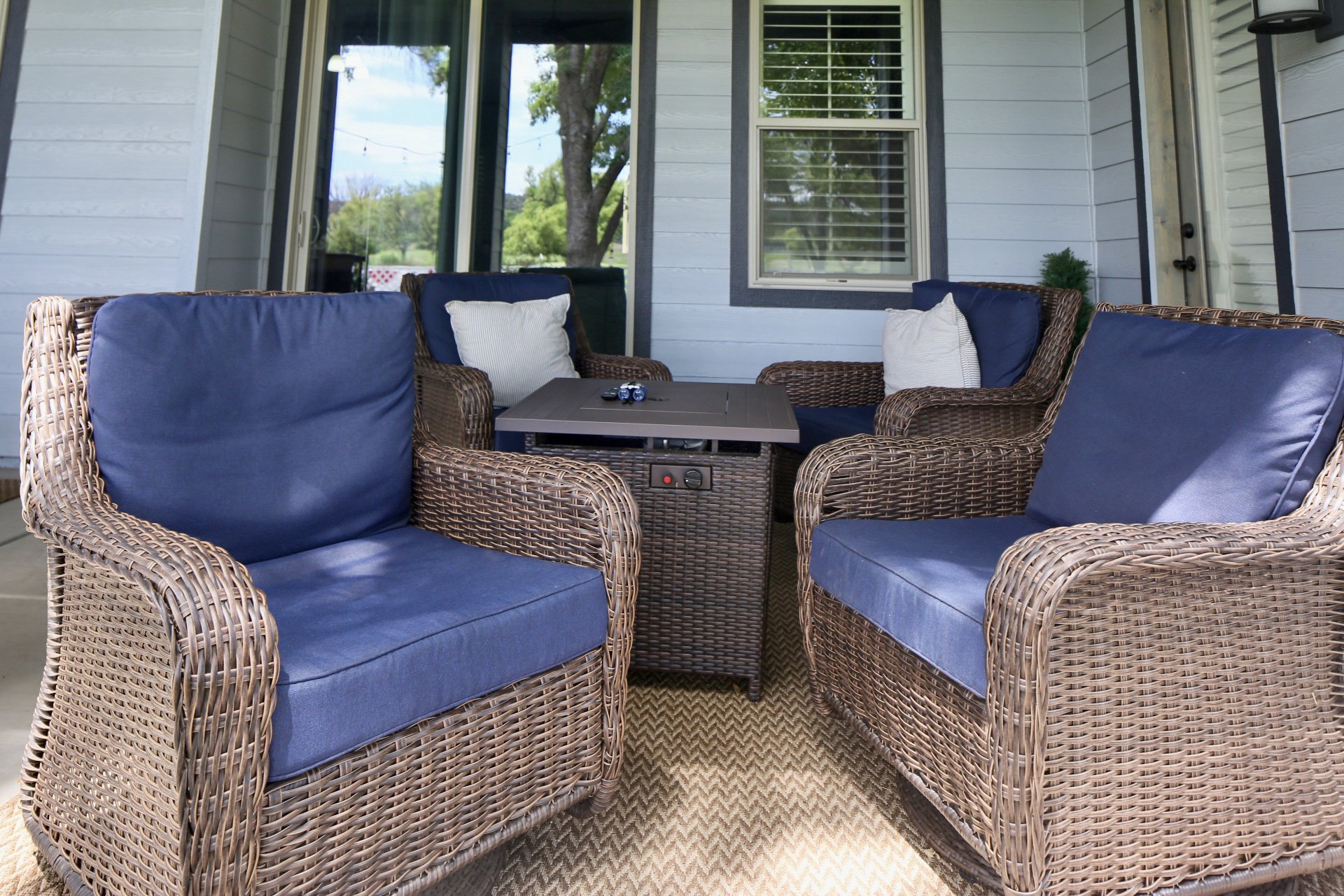 Oversized padded swivel rocking chairs and a propane fire pit table within steps of the home, smartTV, and golf course.