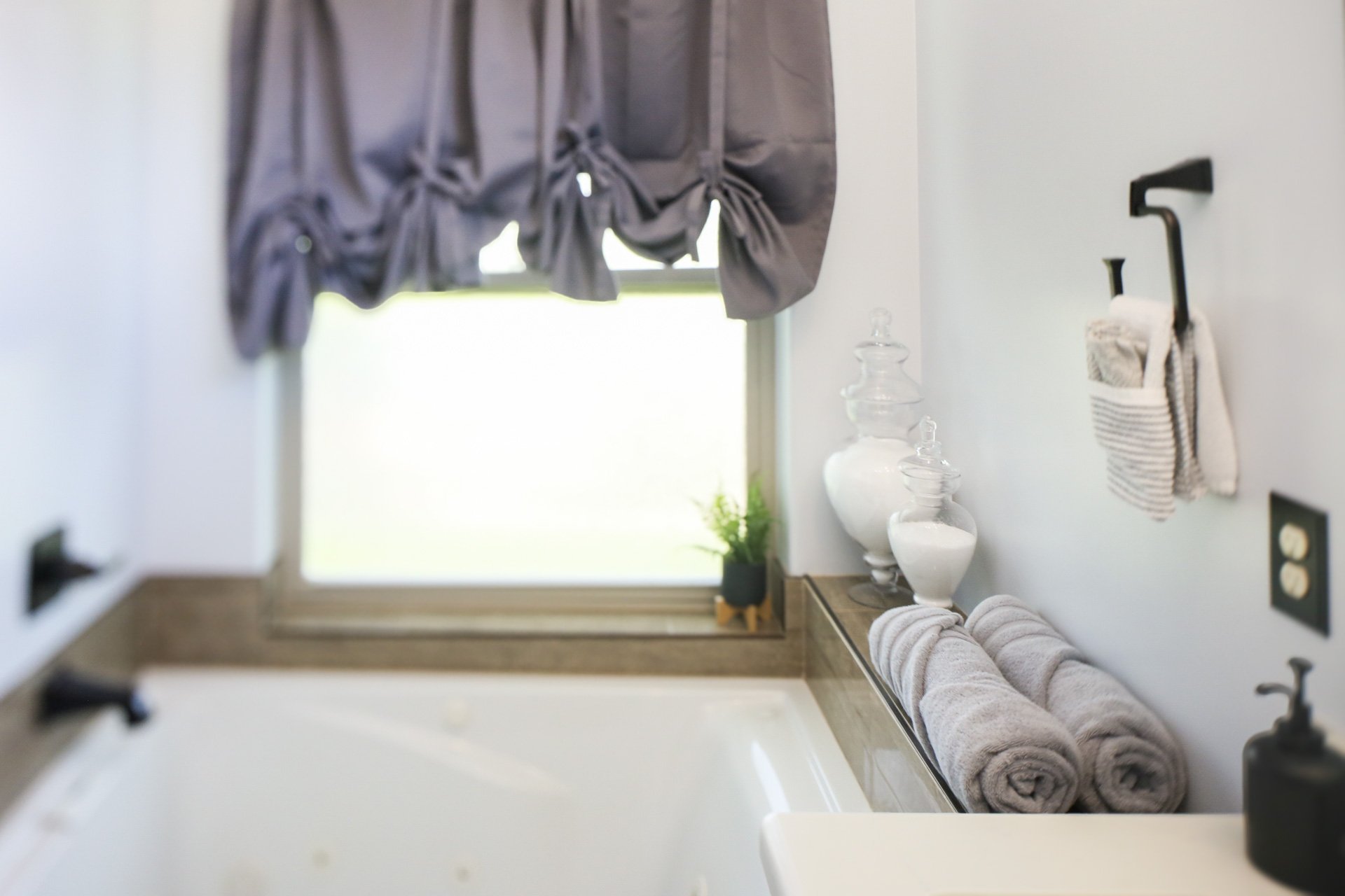 The Clubhouse En-Suite Bathroom has a jetted tub under privacy glass window.