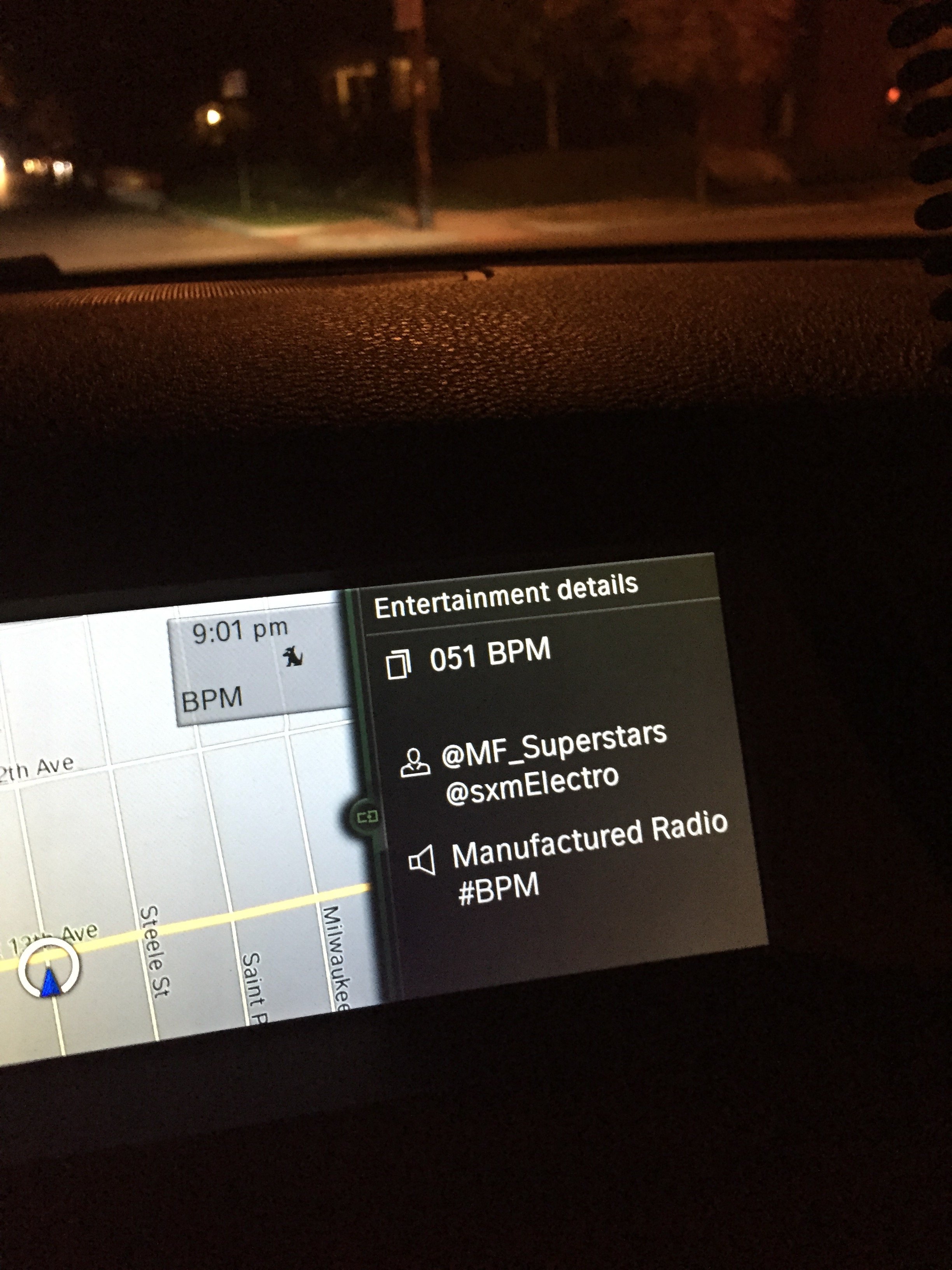 Car GPS screen displaying map and entertainment details, including BPM, social media handles, and radio station.