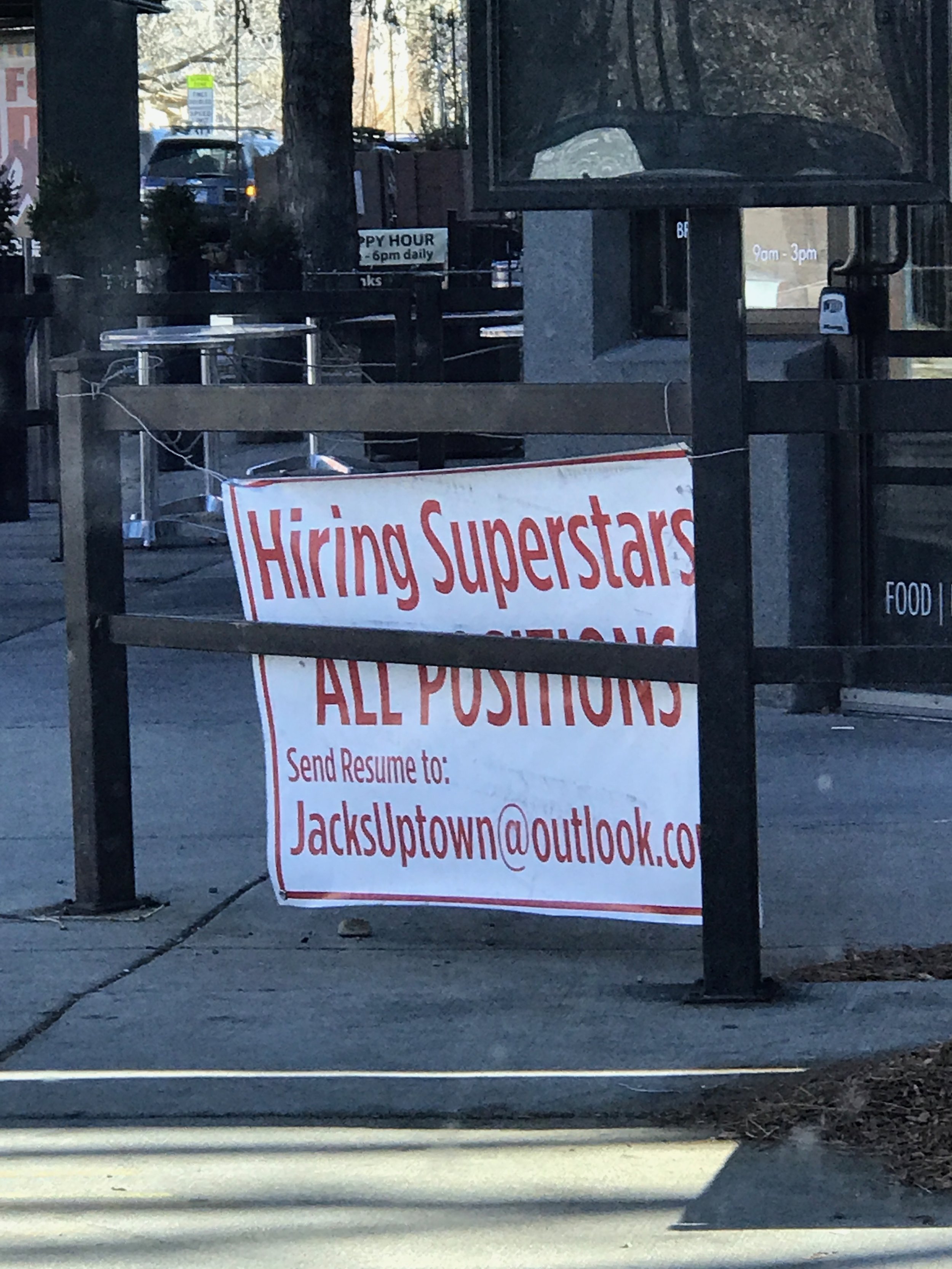 Signboard on sidewalk reads 'Hiring Superstars for All Positions' with an email address for resumes.