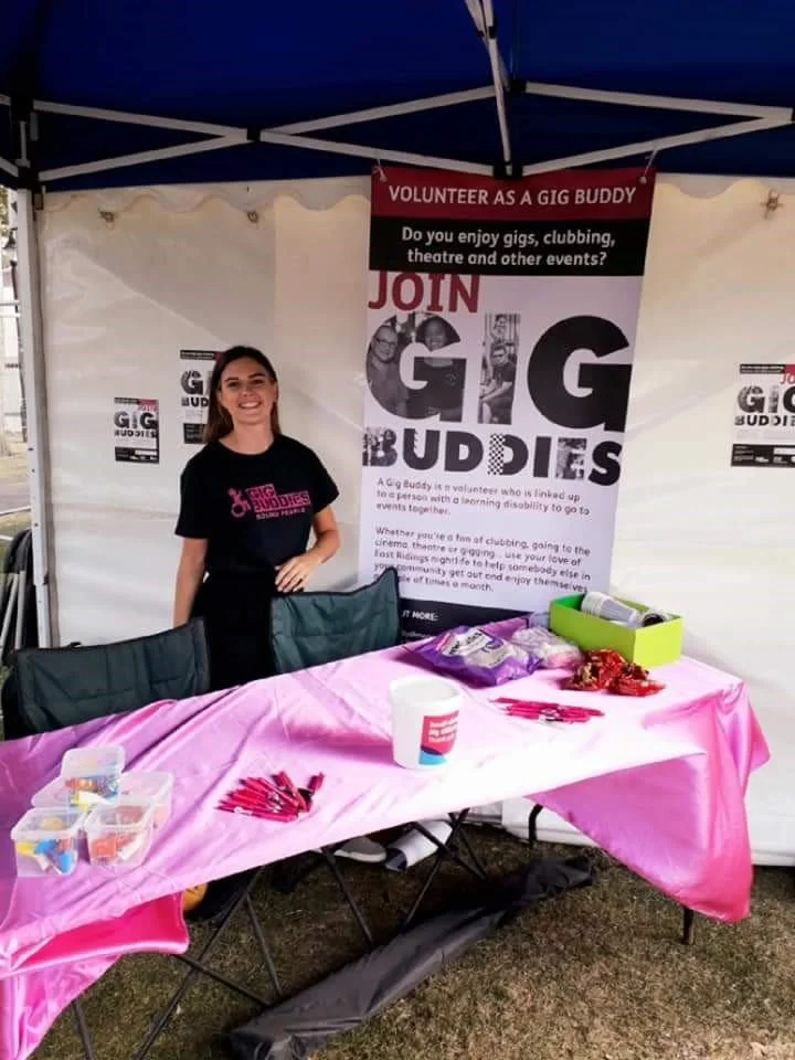 Emily at a gig buddies stall promoting the work of gig buddies back in 2019