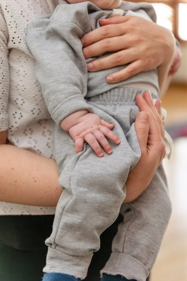 Maman en tenue de sport avec son bébé lors d'un entraînement postnatal