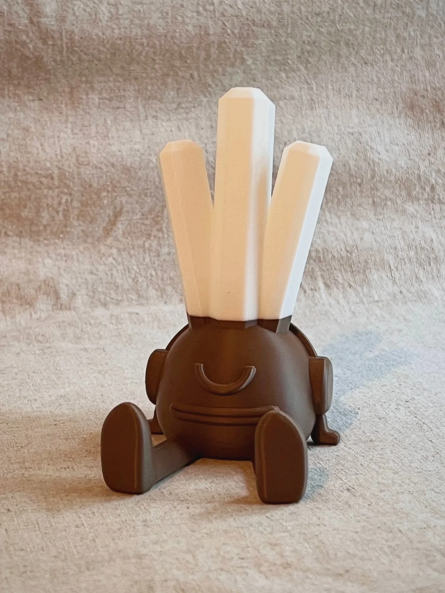 Brown Terry the Enjoyer phone stand with white crystal spikes.