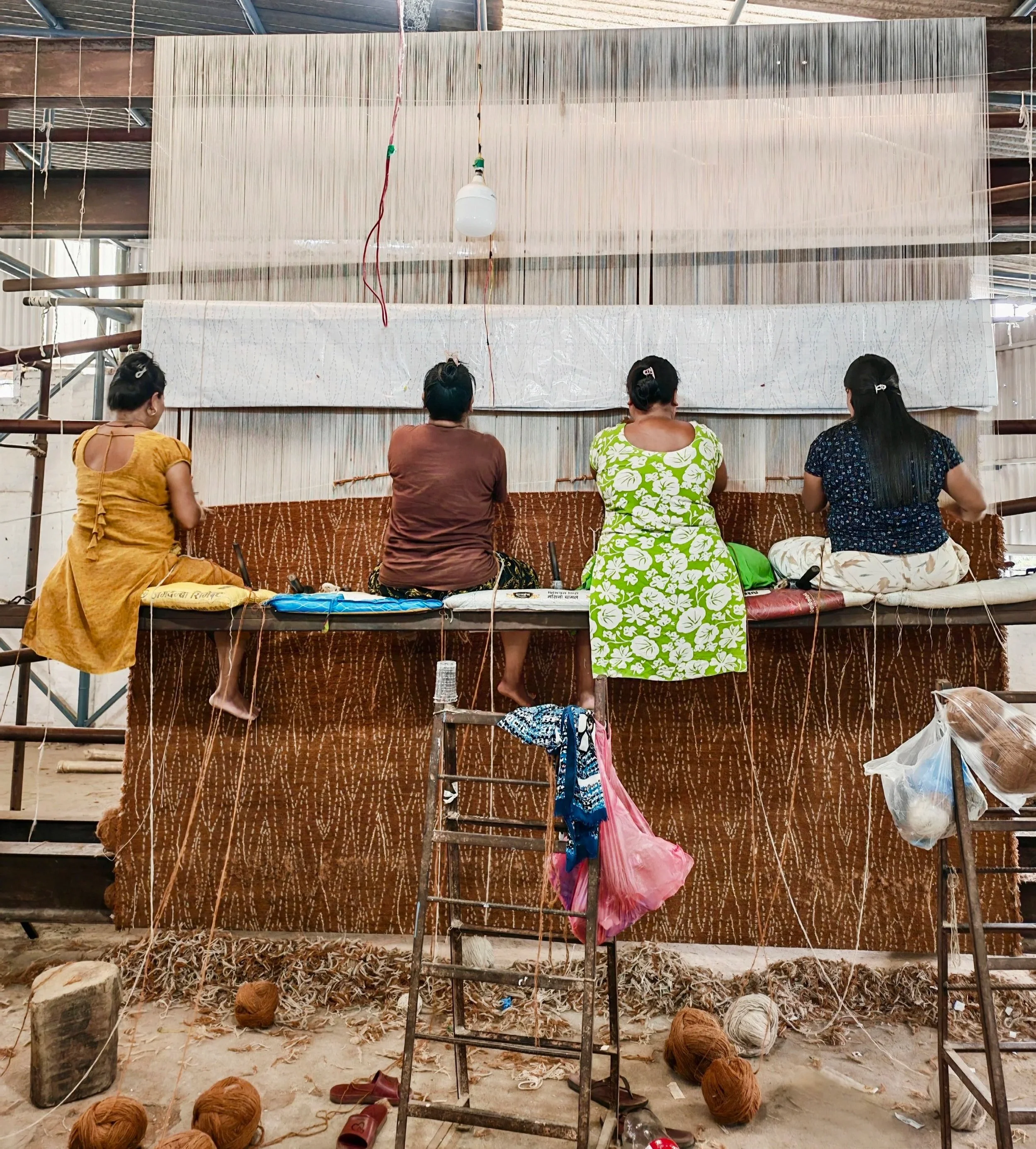 Women Weavers with Odegard Carpets Swarm Design in Serengeti Sand Colorway.