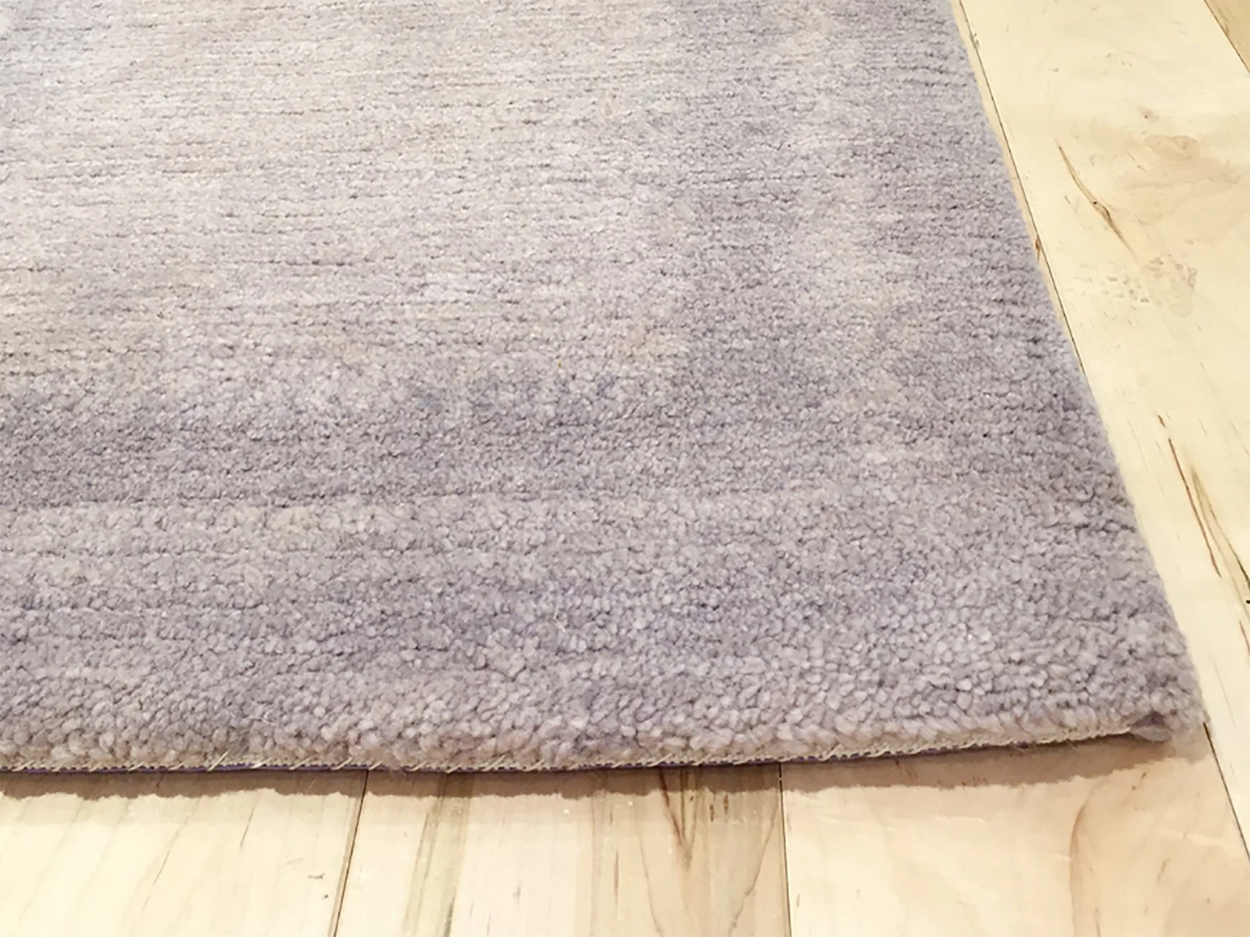 Close-up of a light purple chunky carpet.