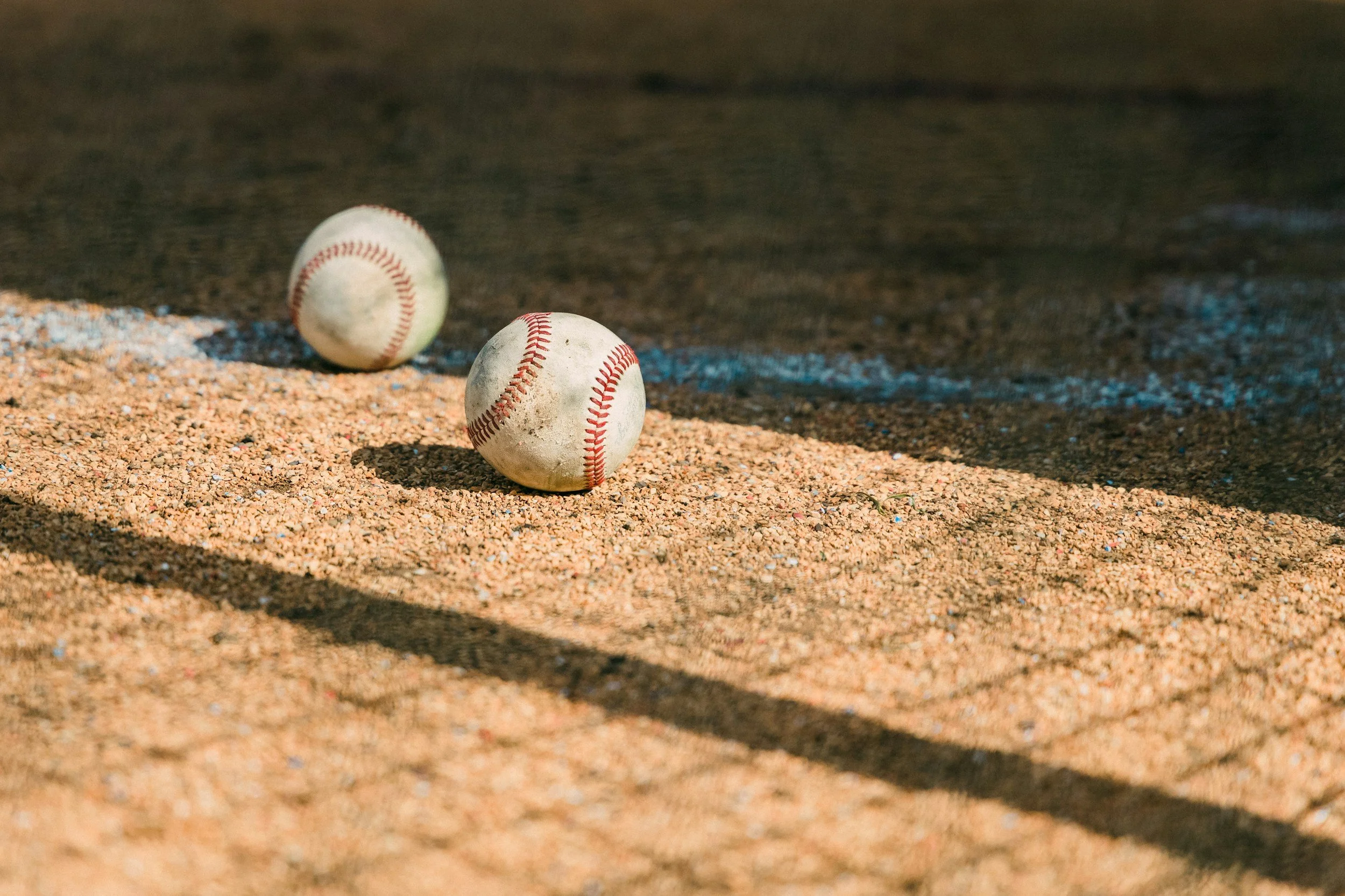 2 baseballs laying in the dirt, a picture taken by Mark Tegethoff.