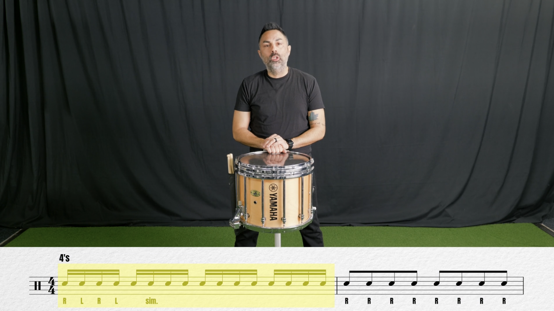 A young man in athletic clothing walking on an outdoor sports court, looking at his wristwatch, with a digital display showing 112 beats per minute.