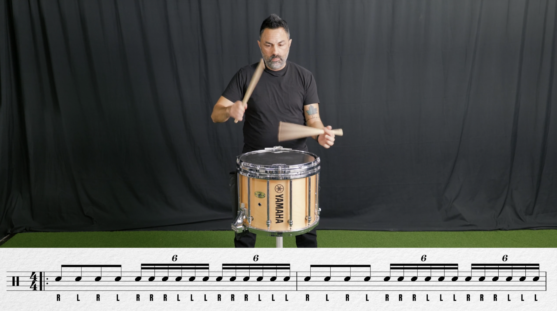 Top-down view of a person standing on a decorated basketball court with a center circle, and marked lines and numbers.