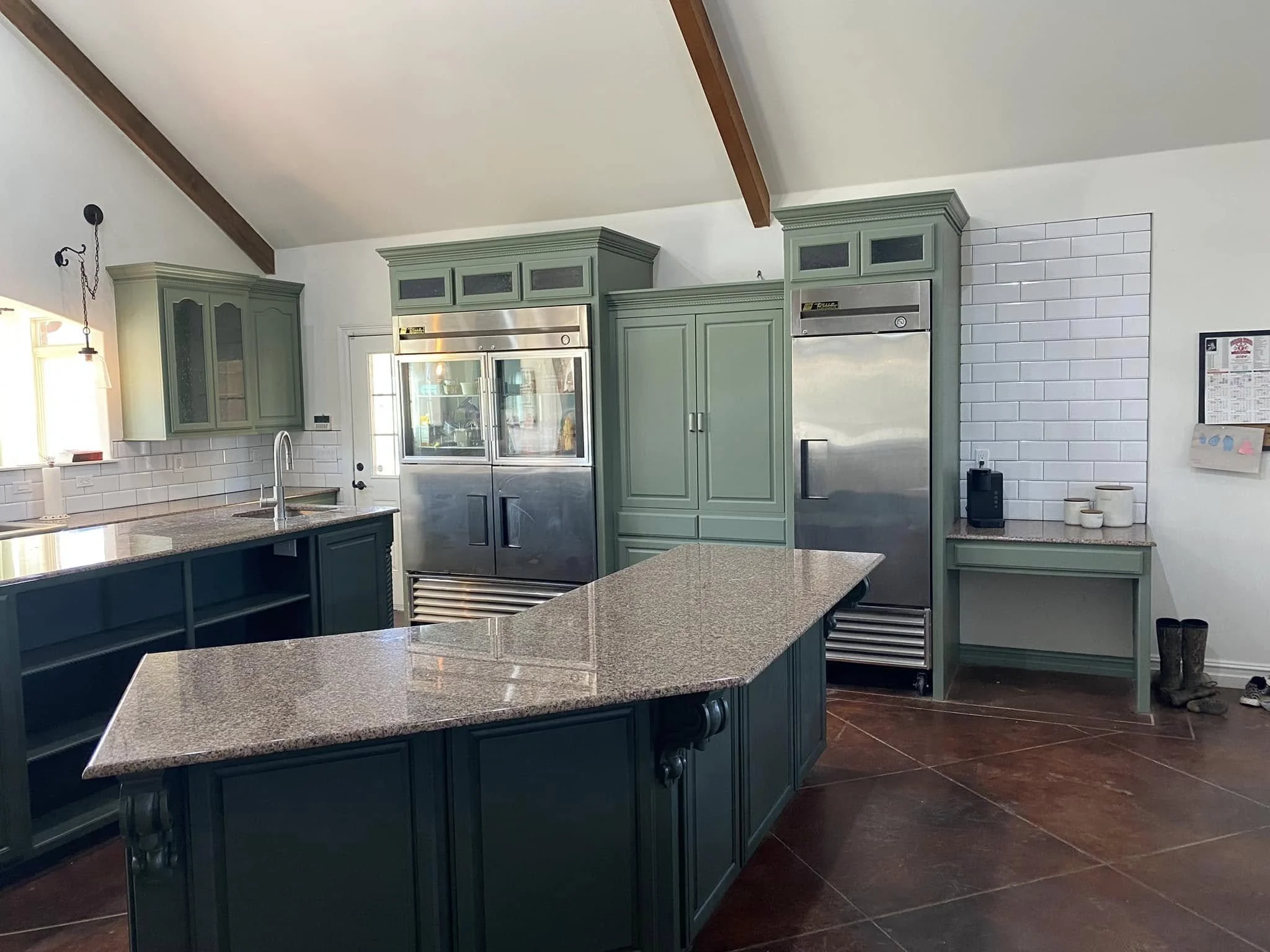 Kitchen with green cabinetry, granite countertops, stainless steel appliances, white subway tile backsplash, and hardwood floors.