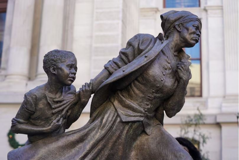 Bronze statue depicting a woman being pulled away by a young boy.