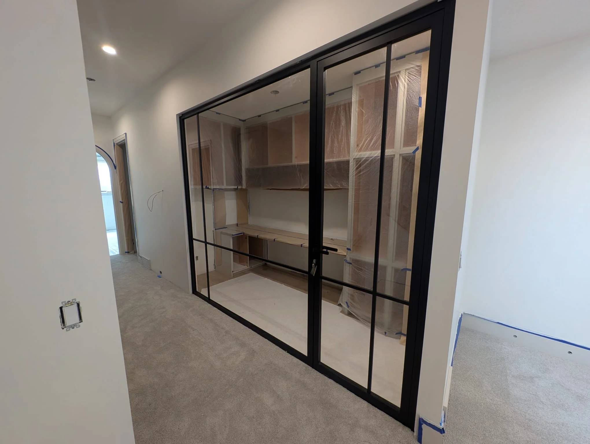 Glass partition wall for a small home office, featuring a locking door, thin-profile aluminum frame, and clear glass.