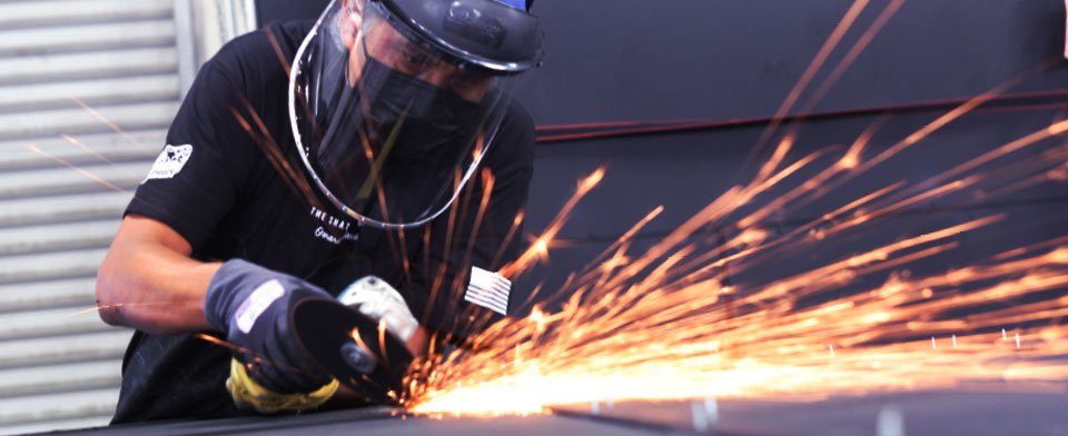 Person welding metal, sparks flying.