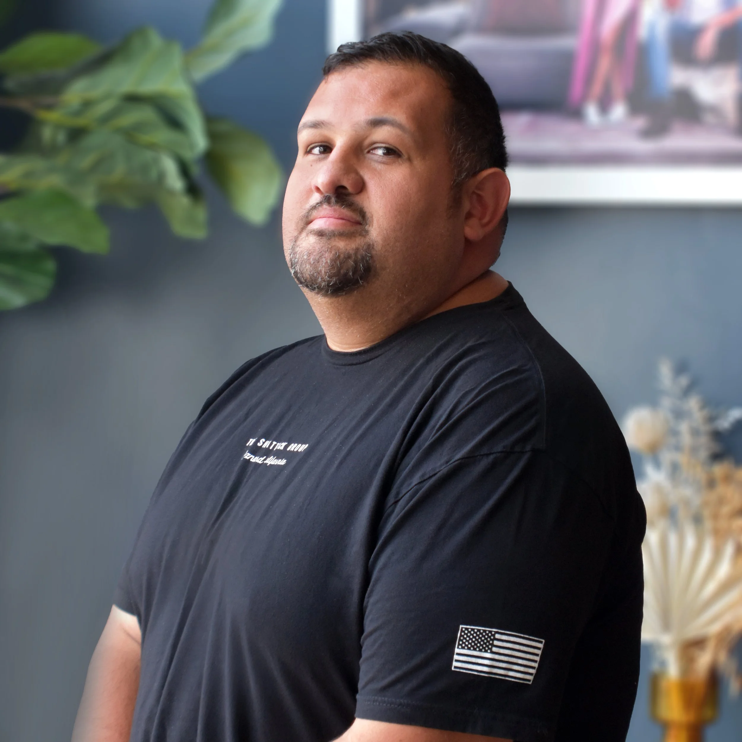 A grayscale illustration of a man with short hair, wearing a suit and tie, with his face not detailed.