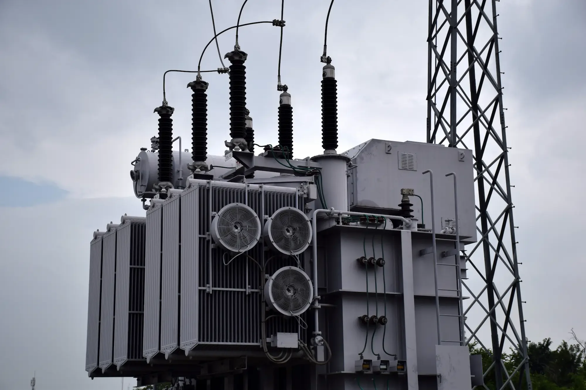 Aerial view of a solar farm with rows of photovoltaic panels and white inverter boxes.