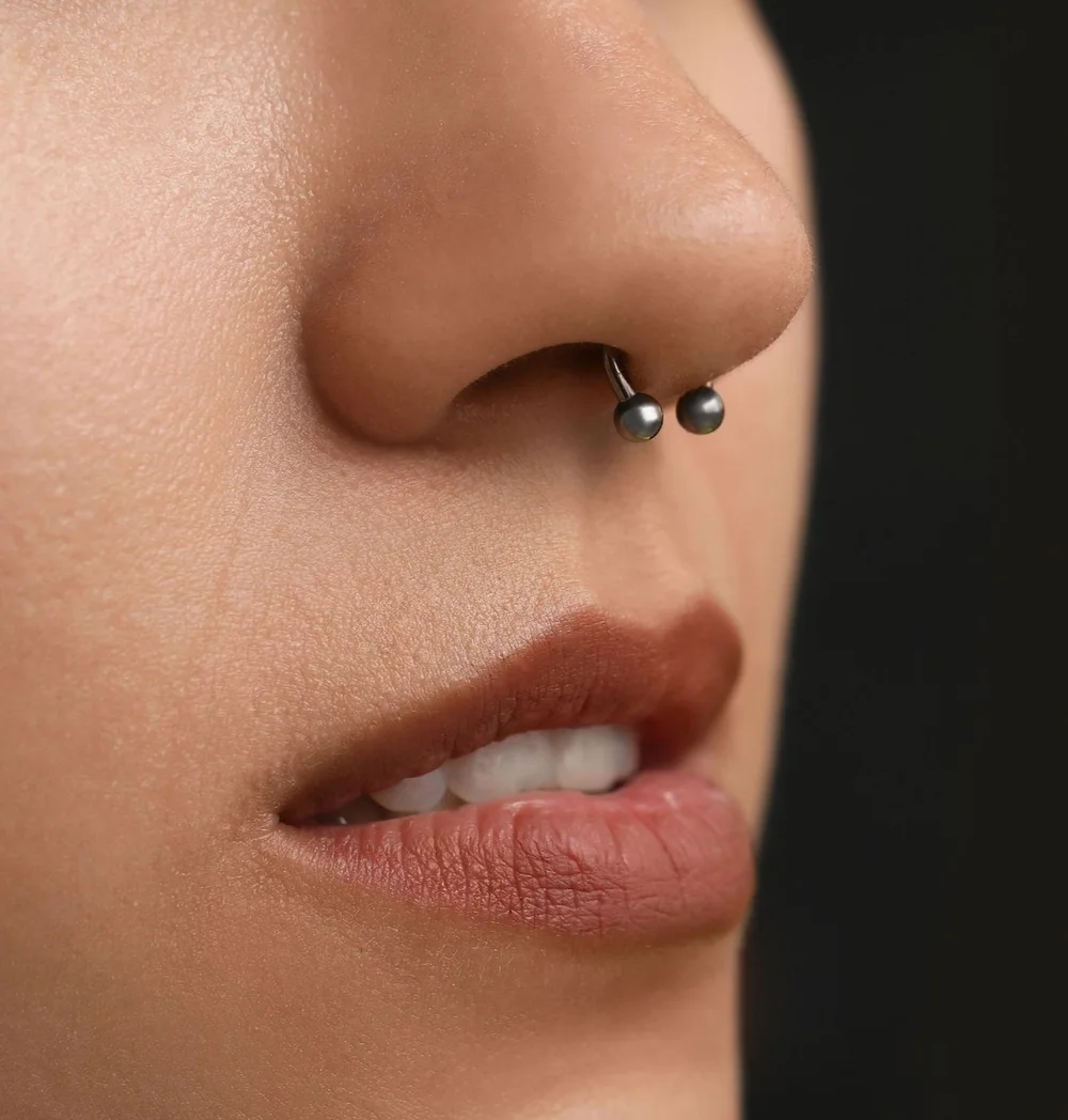 Close-up photograph of a septum piercing
