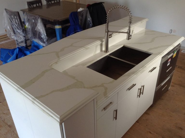Modern kitchen island with cream-colored marble countertop, undermount sink, and a gooseneck faucet.