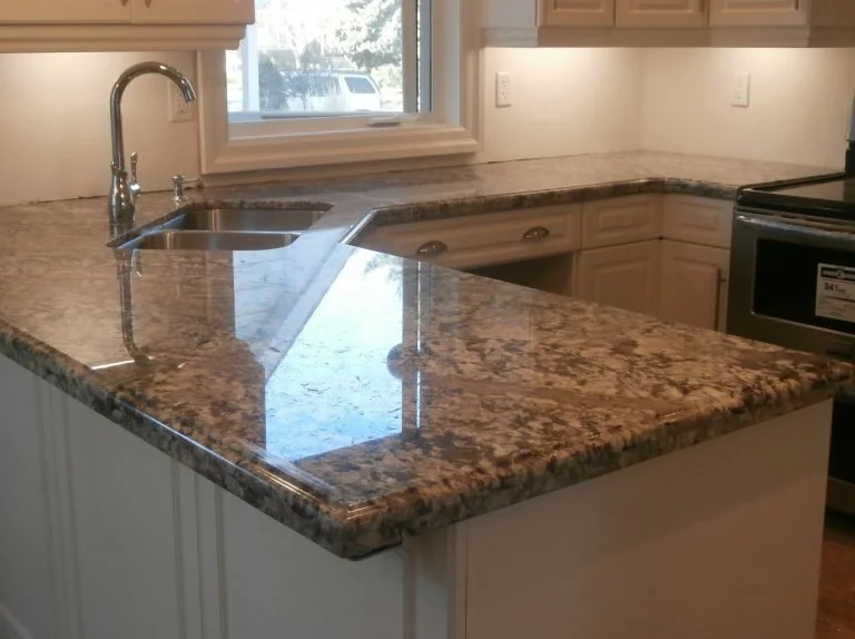 Kitchen with granite countertop, sink, faucet, window, and stainless steel oven.