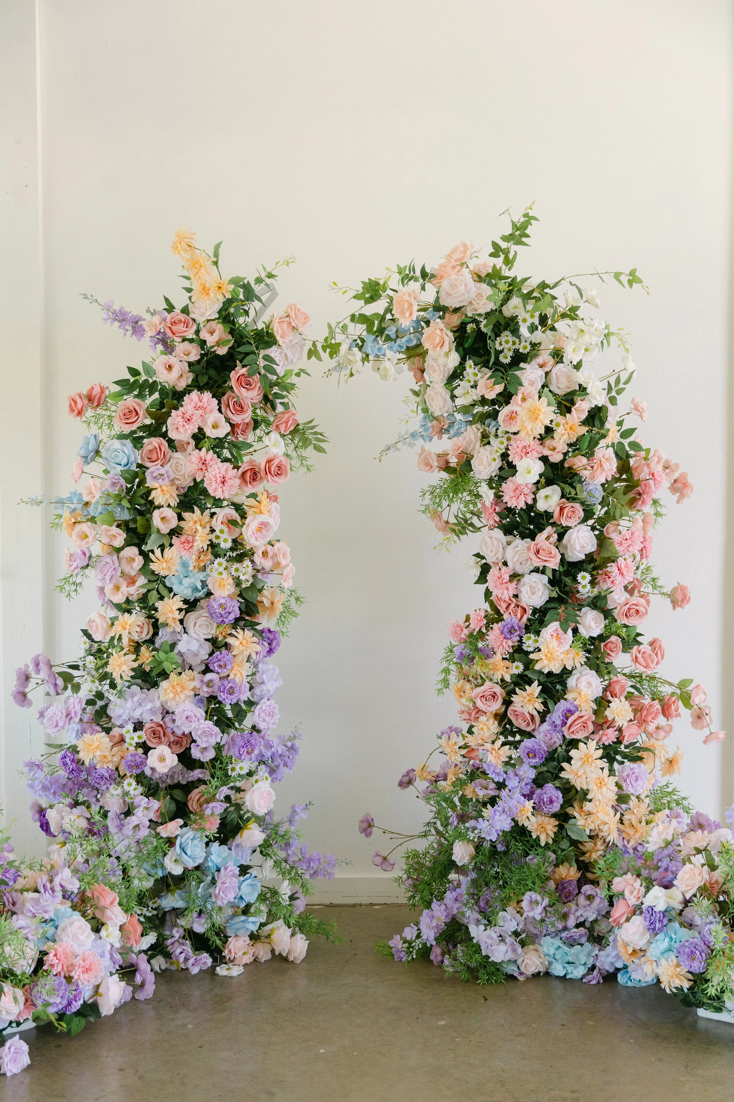 Colorful floral arrangements with pink, purple, white, and blue flowers against a neutral background.