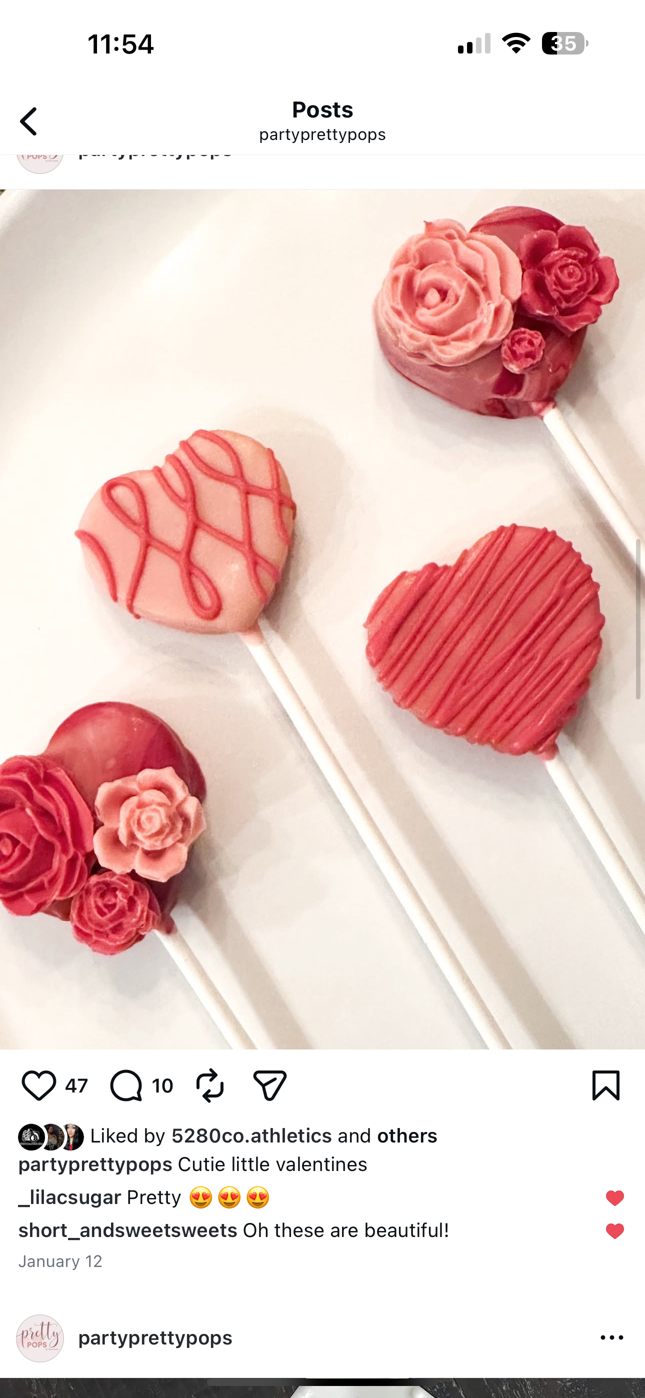 Three pink and red heart-shaped Valentine lollipops decorated with flowers and drizzles, arranged on a white surface.