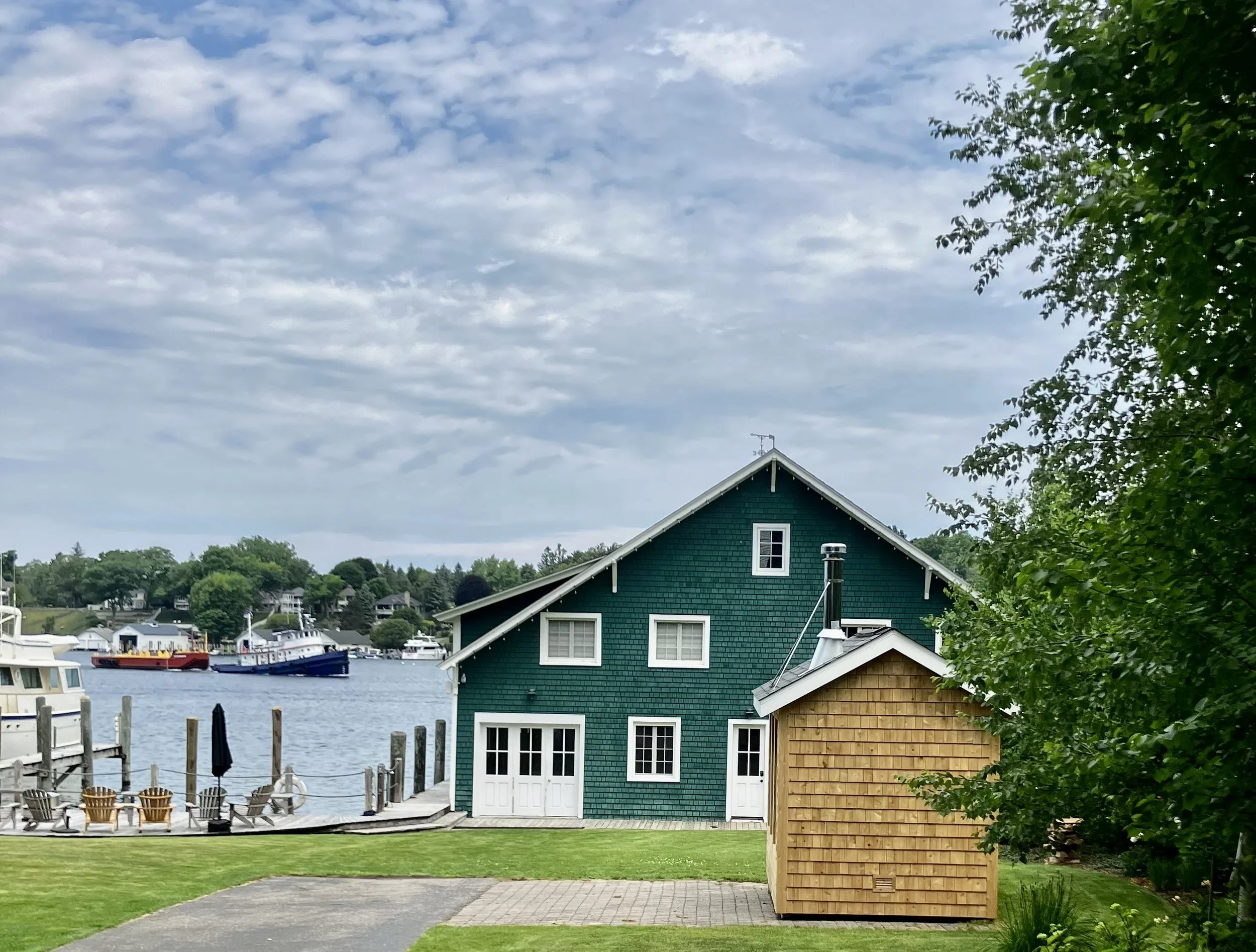 Waterfront on Lake Michigan custom outdoor wood burning sauna next to a historic, charming boathouse.