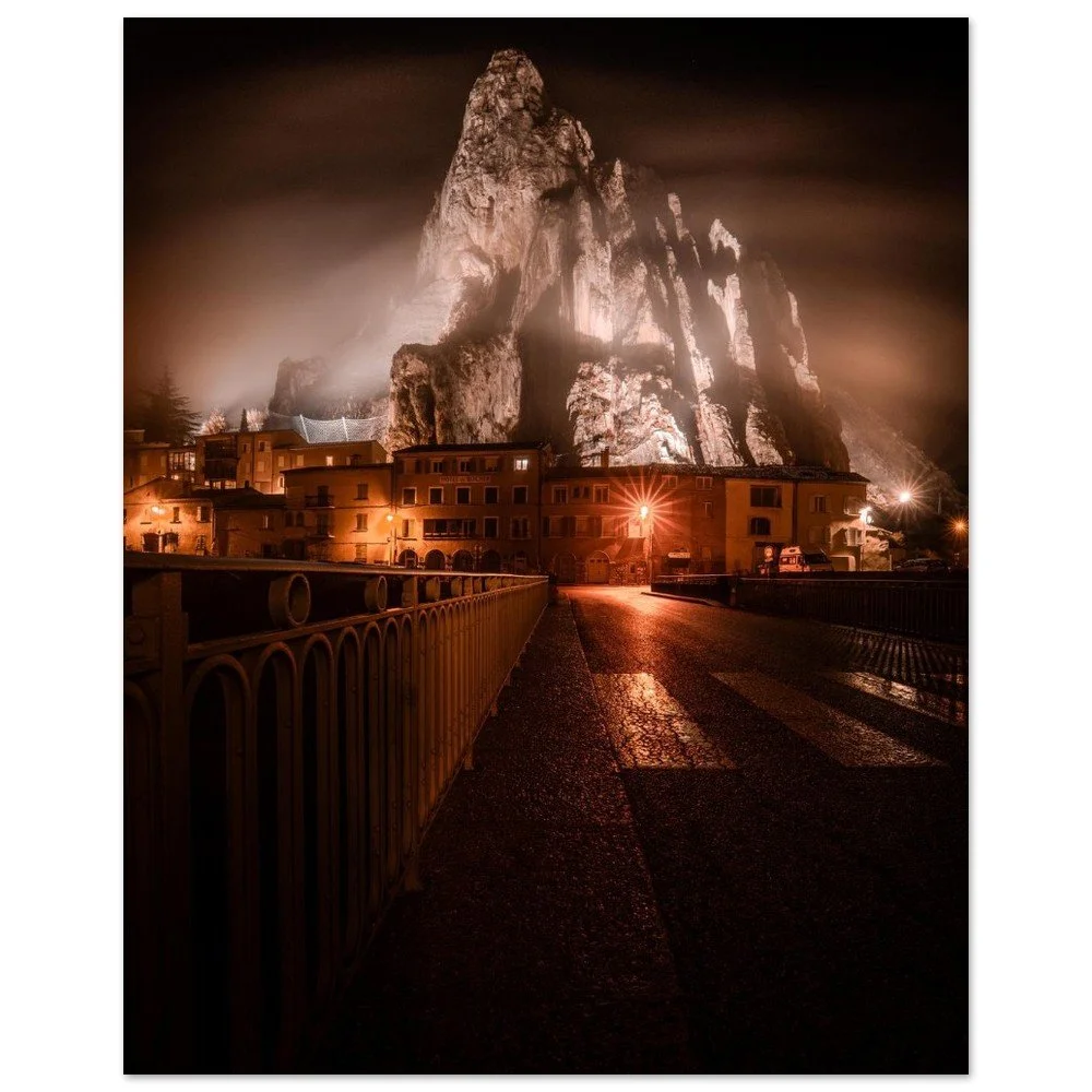 Sisteron illuminated at night beneath the Rocher de la Baume, France