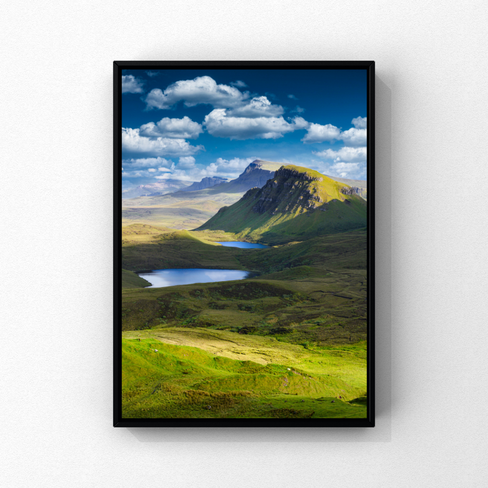 Sunlit green ridges and lochs at the Quiraing on the Isle of Skye