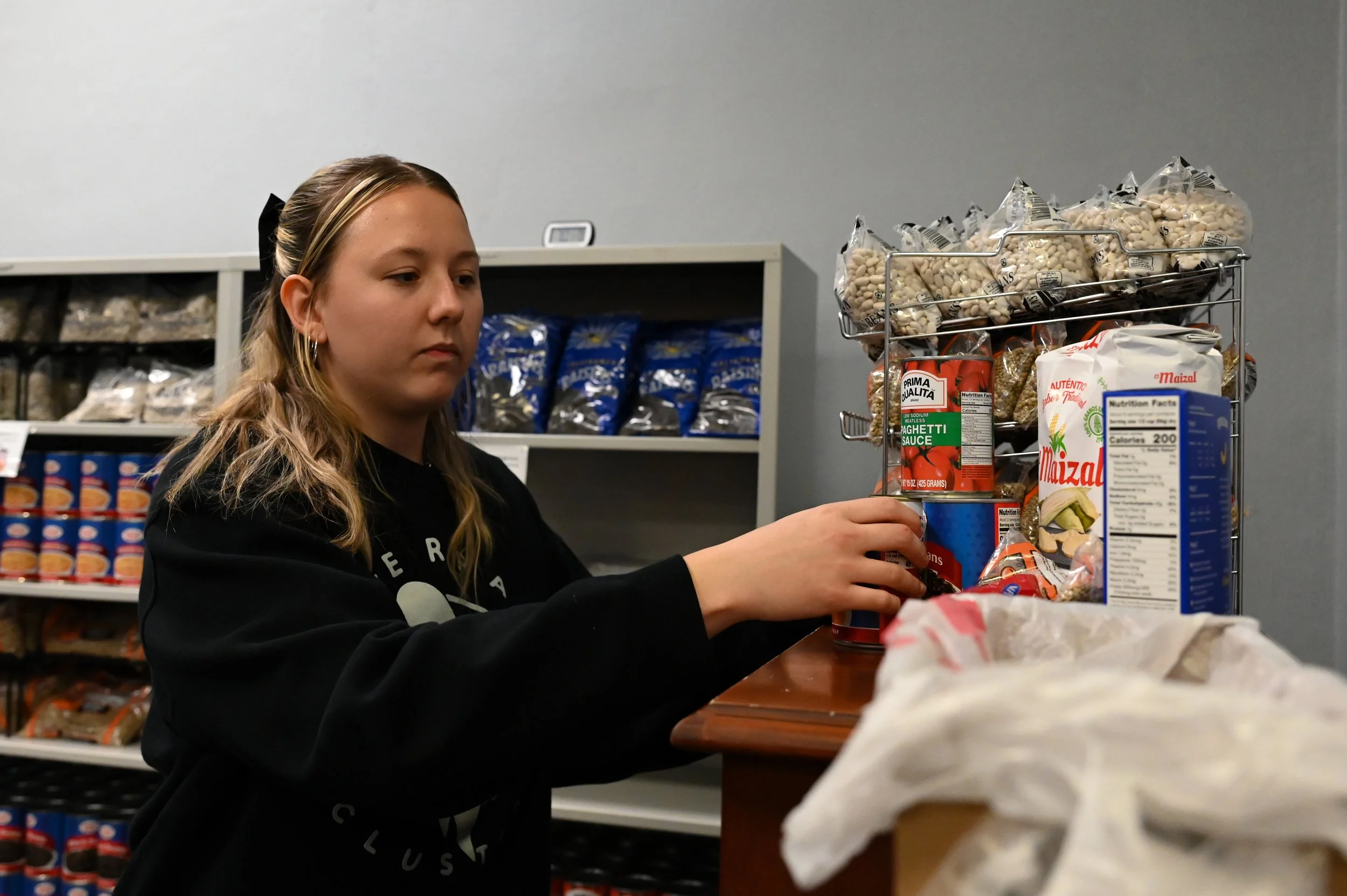 Ava Keresztesy, a volunteer at the Case Western Reserve University community food pantry, organizes supplies during the federal shutdown in Cleveland, Ohio, Oct. 31, 2025. (Photo/Tyler Sun for The Observer)