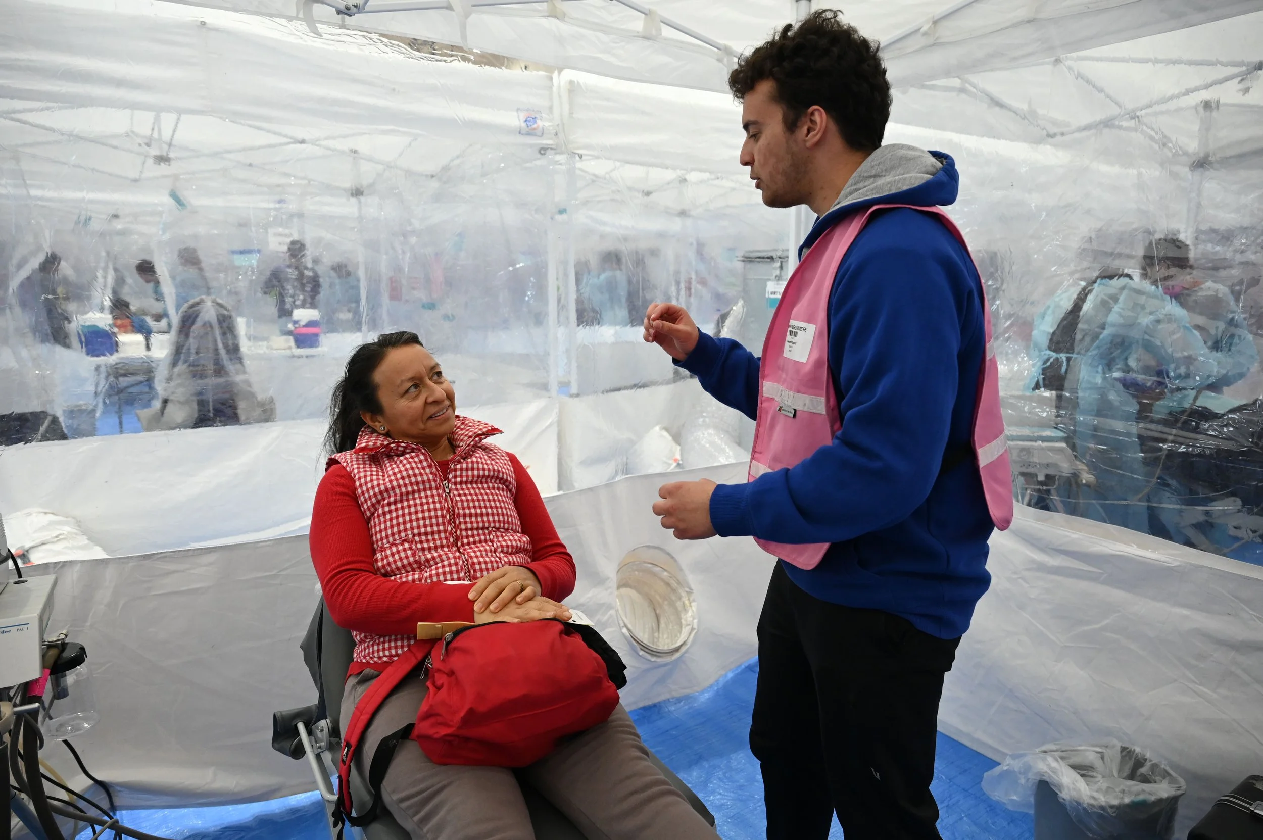 Aiden Brummer, a University of Kentucky student, talks to Elida in Spanish at a Remote Area Medical clinic in Columbus, Ohio, Nov. 9, 2025. Brummer served as her interpreter for dental services.