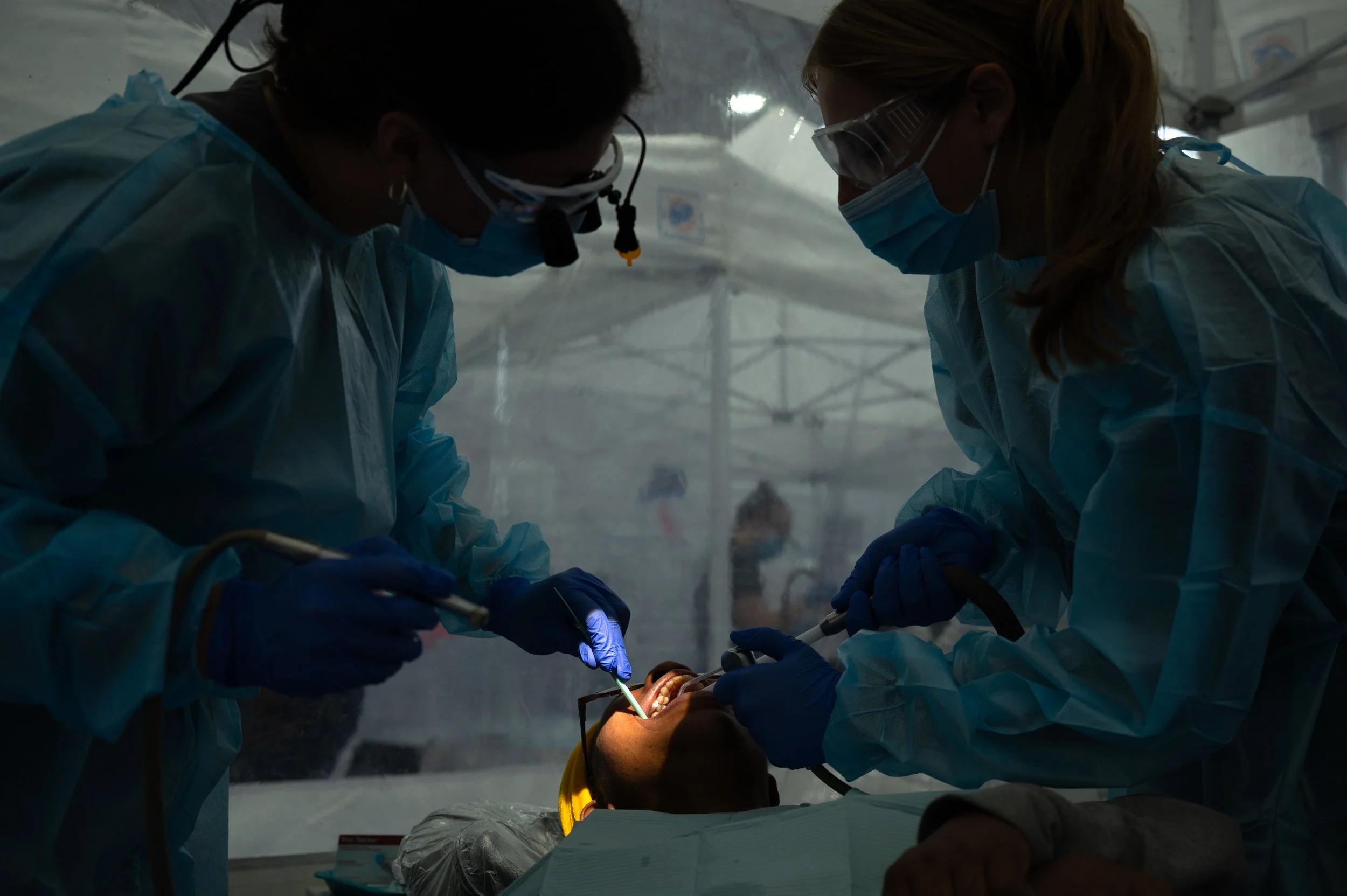A dental student and undergraduate student from Ohio State University fill a cavity for Lu at a Remote Area Medical clinic in Columbus, Ohio, Nov. 9, 2025.