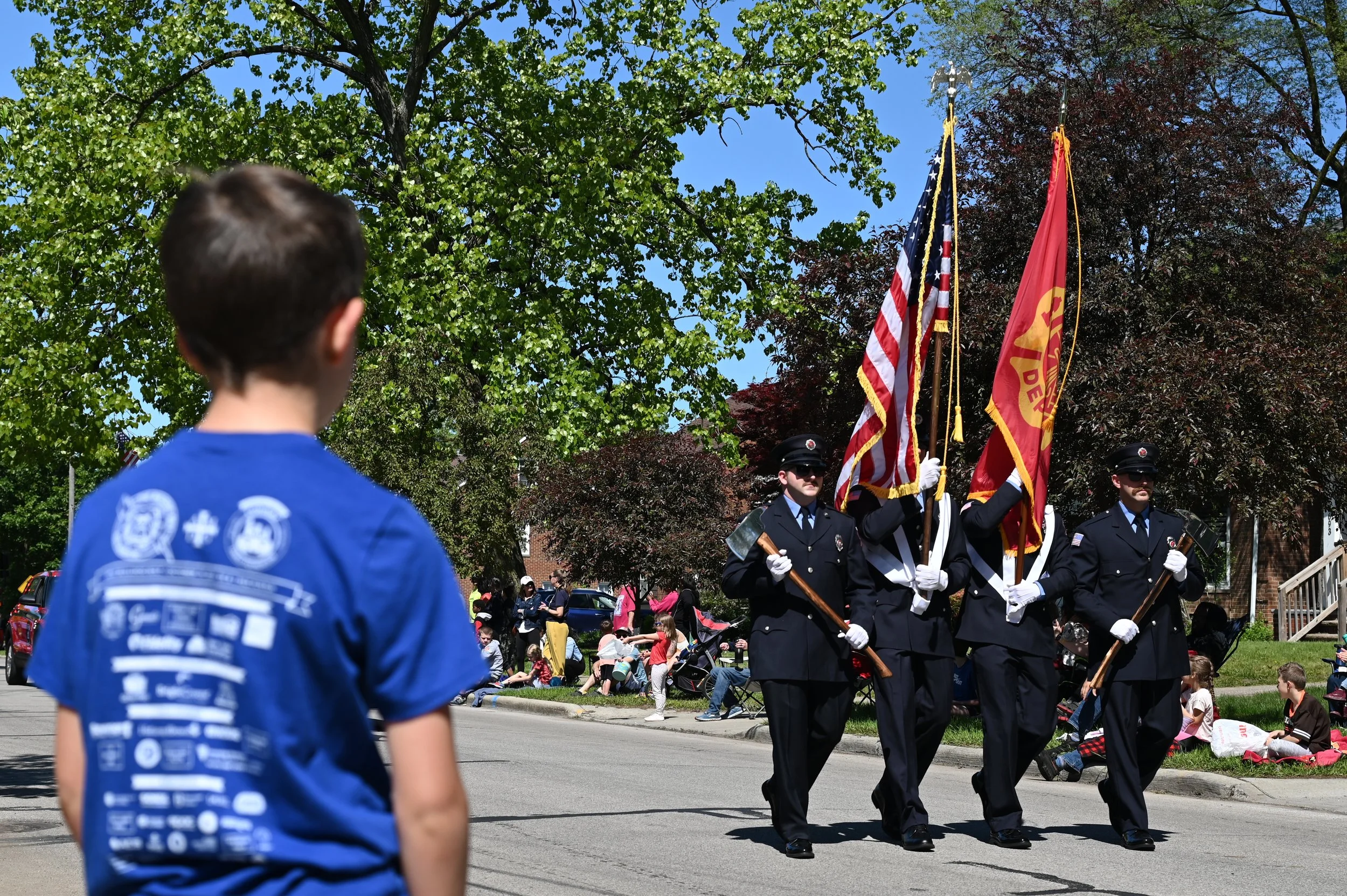 A child in the foreground watches firemen from the University Heights Fire Department march at a Memorial Day parade in University Heights, Ohio, May 26, 2025.