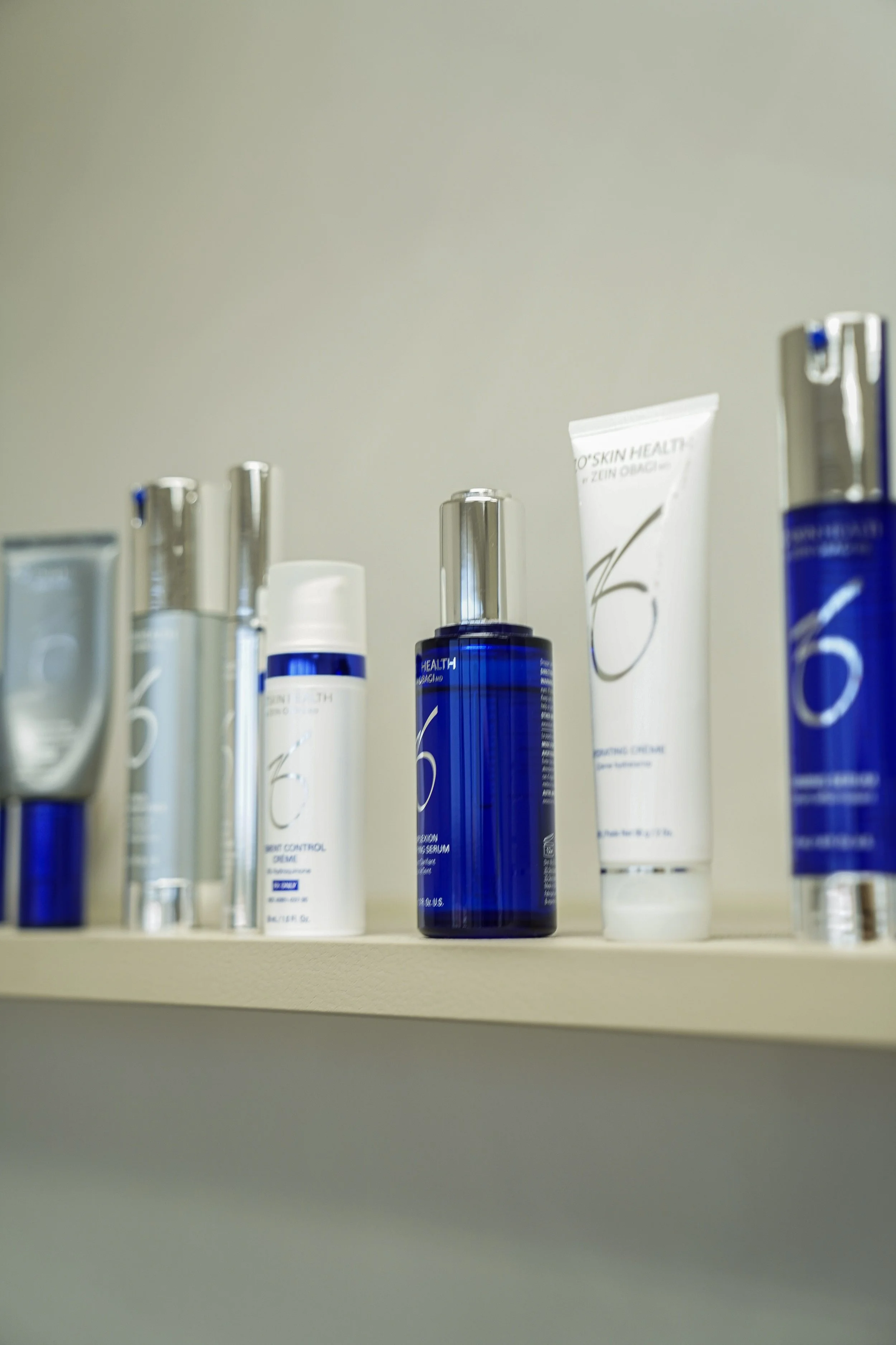 Collection of skin care and cosmetic bottles and tubes on a shelf.