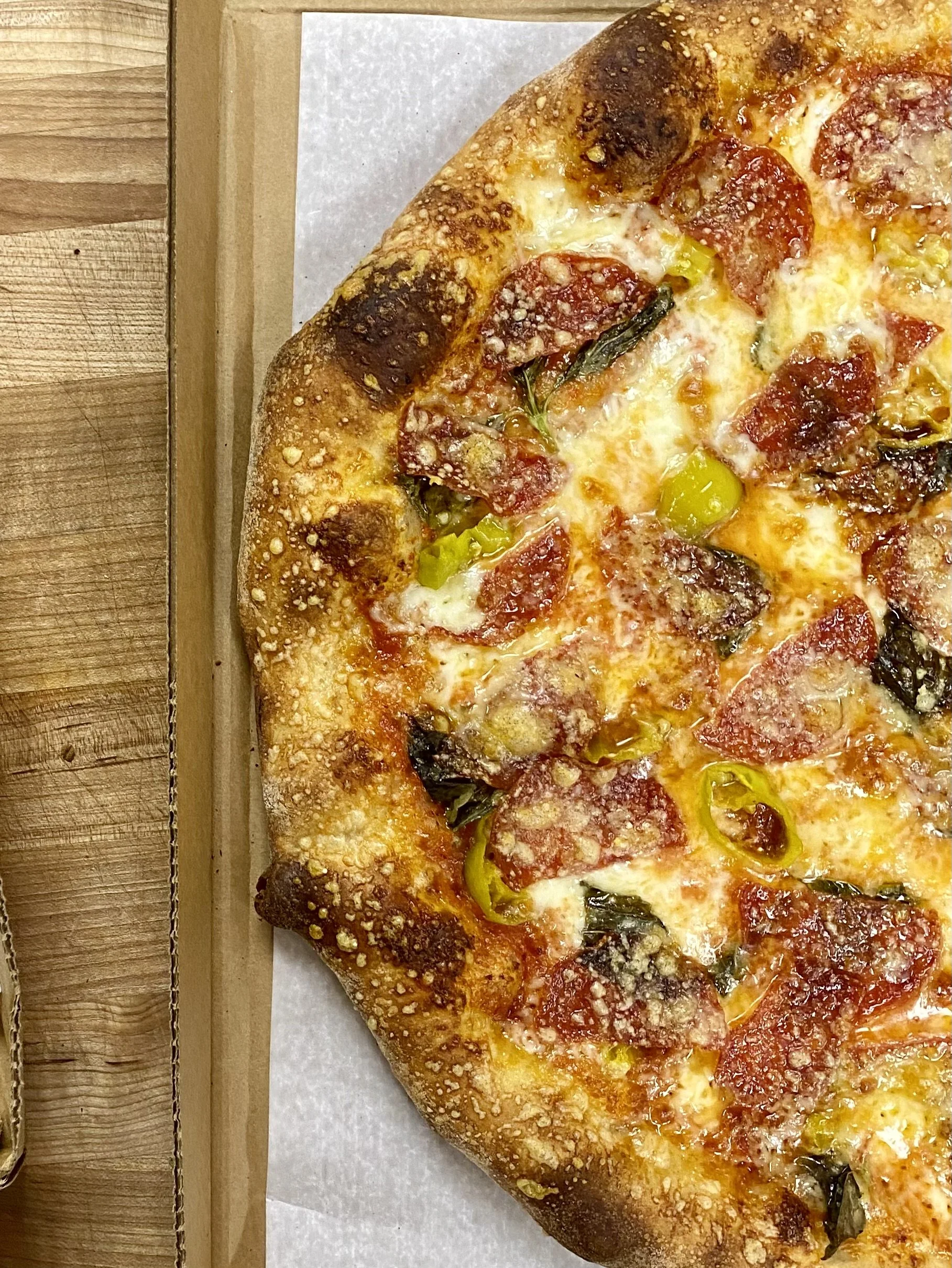 Fresh baked sourdough crust pizza dough, topped with pepperoni and hot peppers