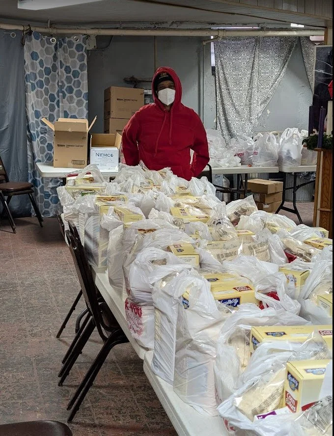 One of our wonderful volunteers with the final product before we begin passing out the bags to those in need.  