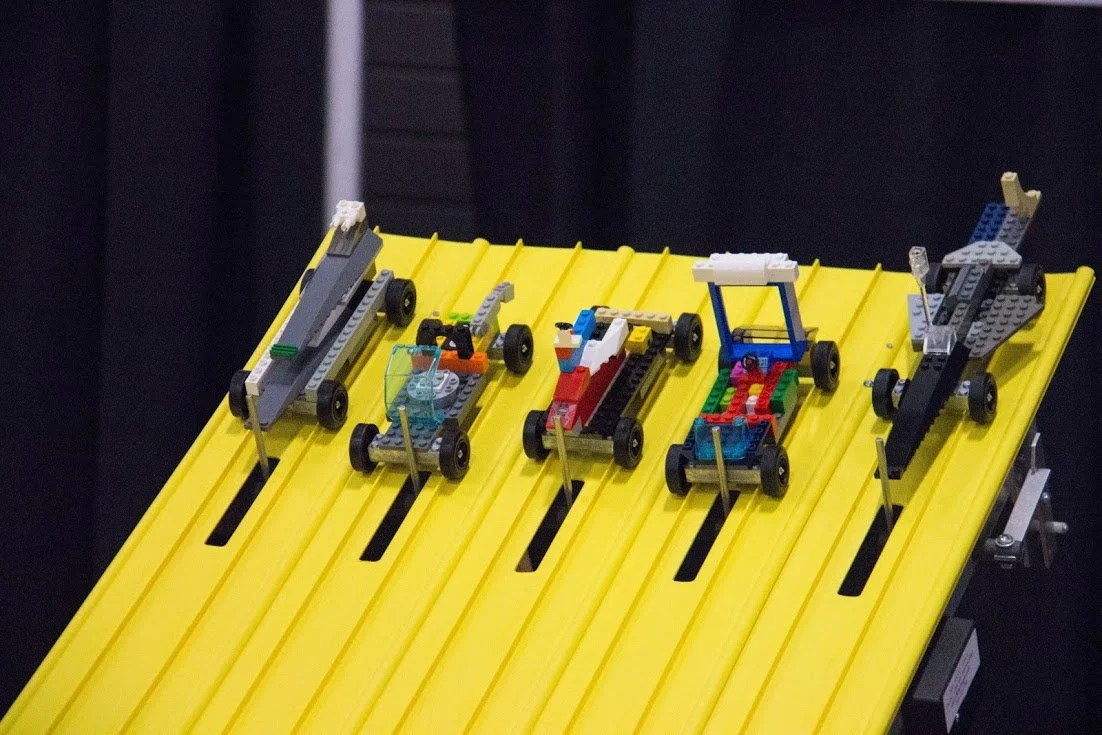 BRICK DERBY RACES BRICK BLAST Five LEGO cars on a yellow racetrack. Blox con 2025 event brick universe brick fest brickfestlive brick con.