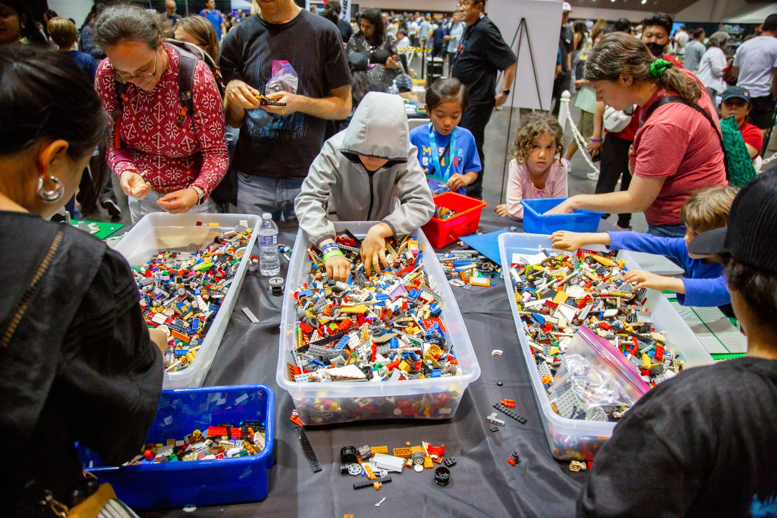 People browsing colorful LEGO bricks at an outdoor event or market, Brick Blast, LEGO Convention, Fan Event, building fun, bulk bricks