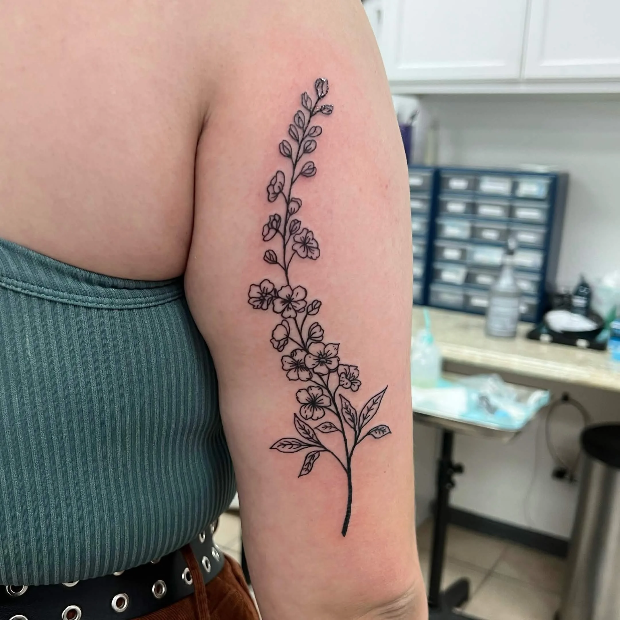 Close-up of a tattoo of a floral design on a person's upper arm.