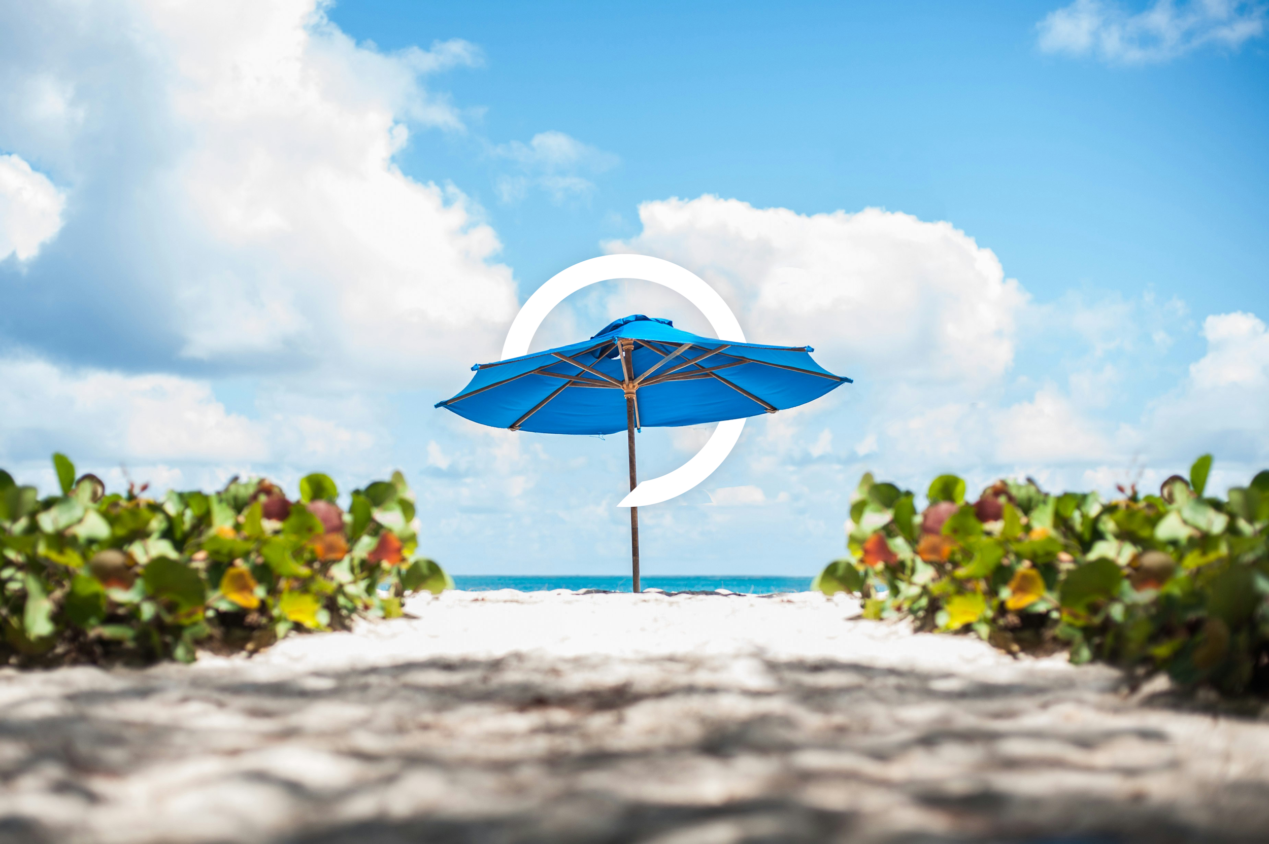 bright blue umbrella in a white sand beach on a beautiful day