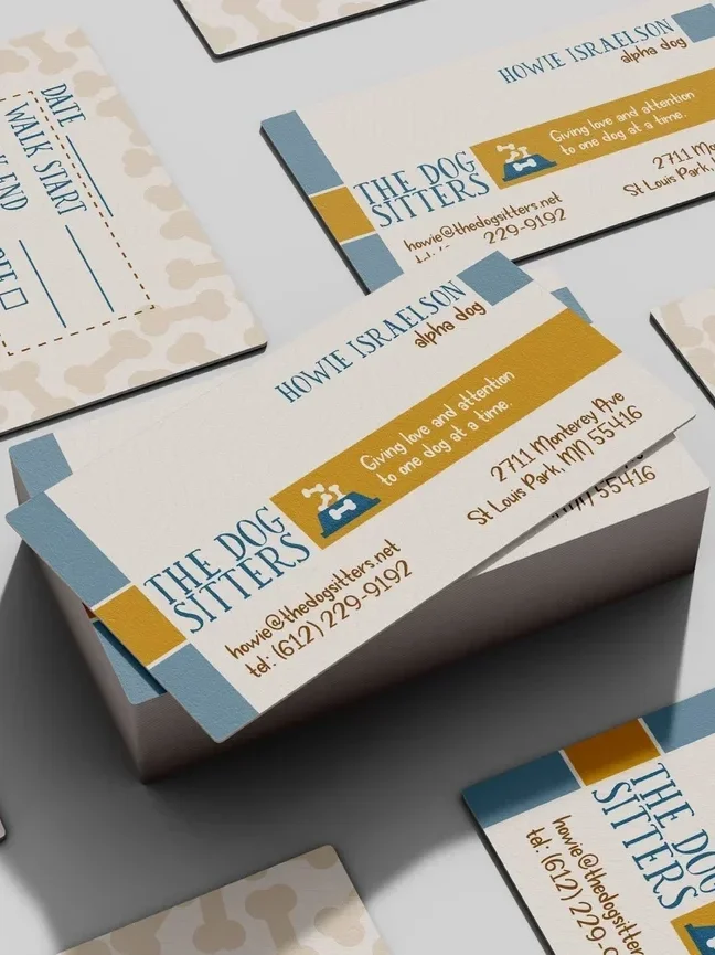 Business cards for The Dog Sitters featuring a blue and gold color scheme, a logo of a dog dish and bone, the name Howie Isaelson, and contact information including an email and phone number.