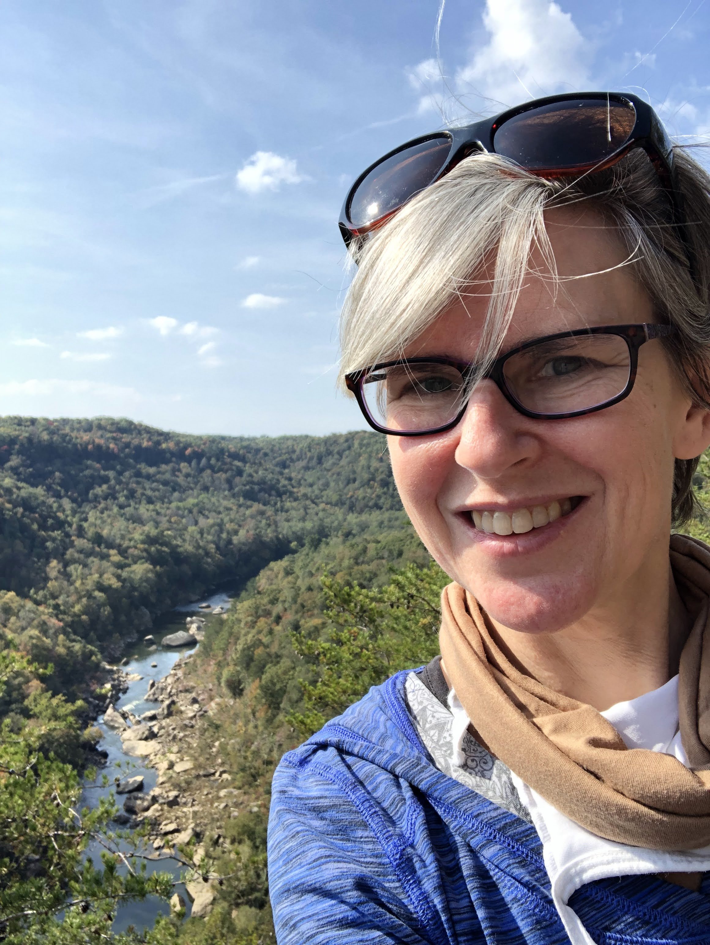 lisa's face, wearing glasses, river valley behind her