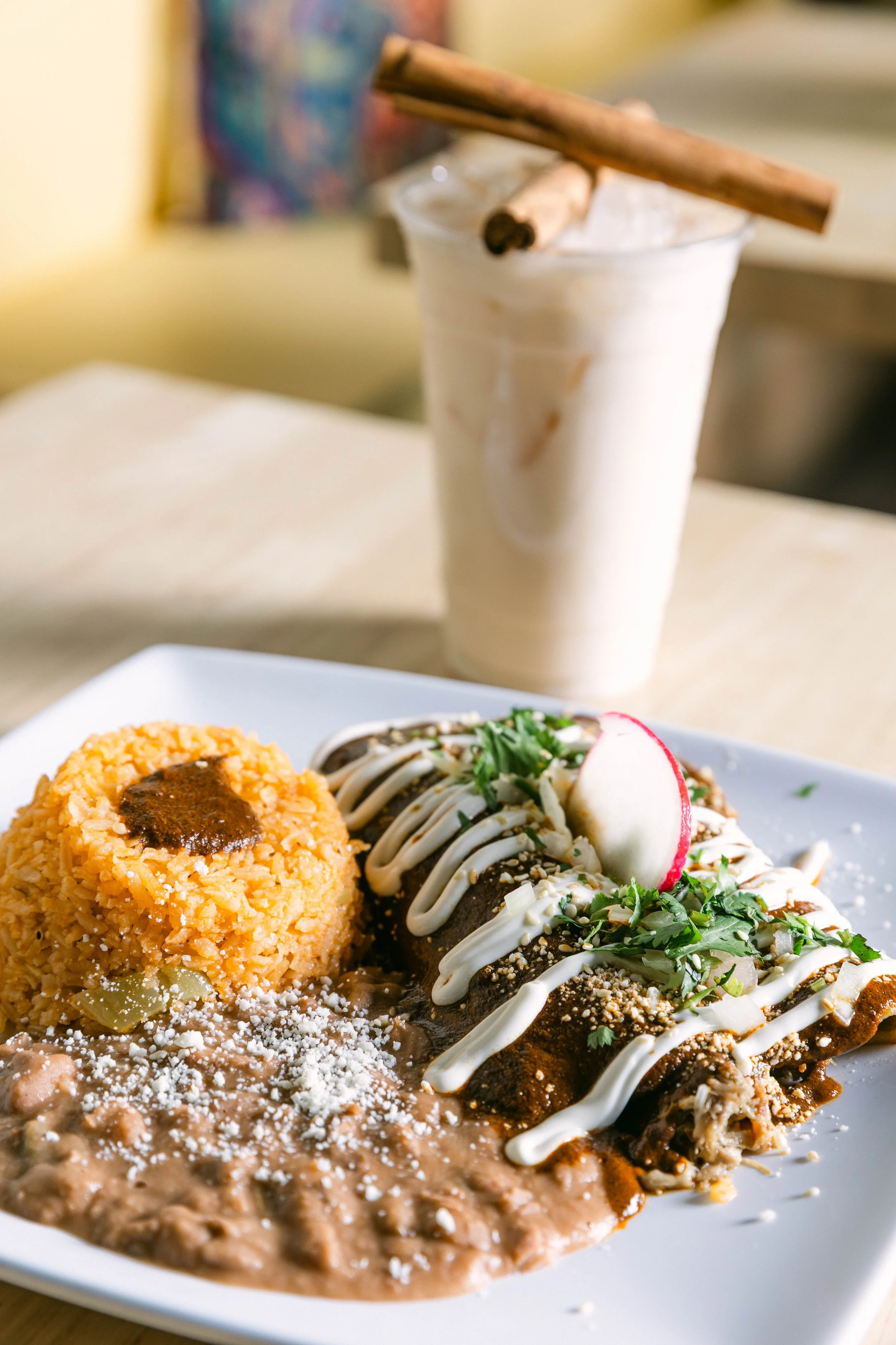 Authentic Mexican mole plate with rice and refried beans, served with a refreshing glass of horchata at Poblano Pepper Restaurant in Portland, Oregon