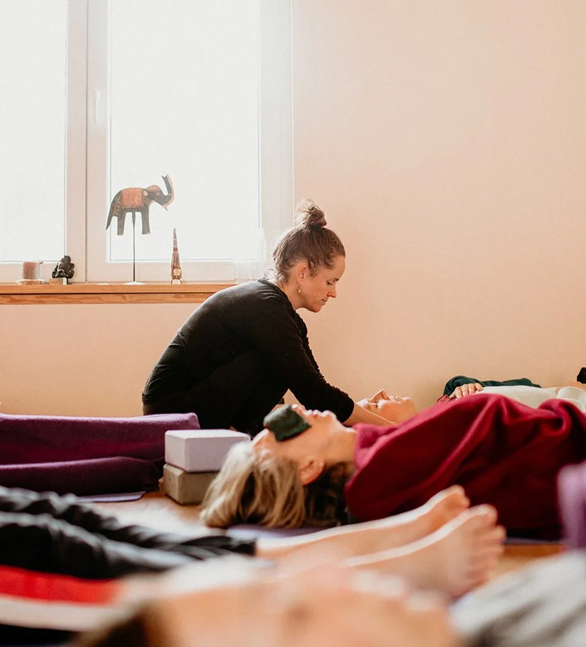 Fiona MacLeod massaging students shoulders during shavasana at the end of the yoga session on retreat in Portugal