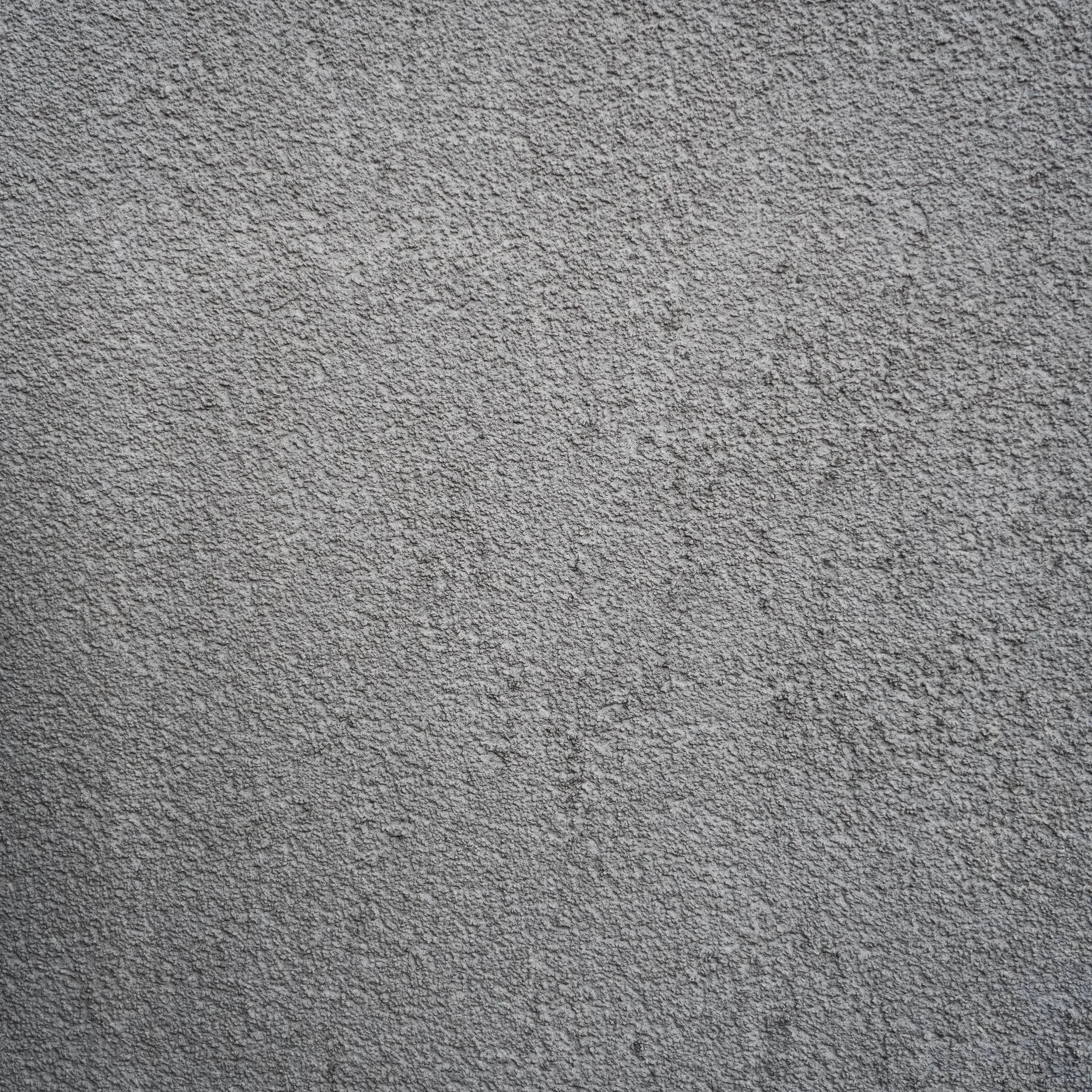 Close-up view of a textured, gray concrete wall surface.