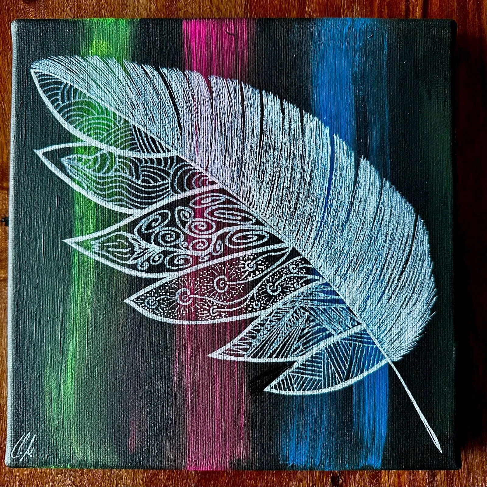 Gemälde einer weißen Feder mit kunstvollen Mustern auf einem bunten, gestrichelten Hintergrund.