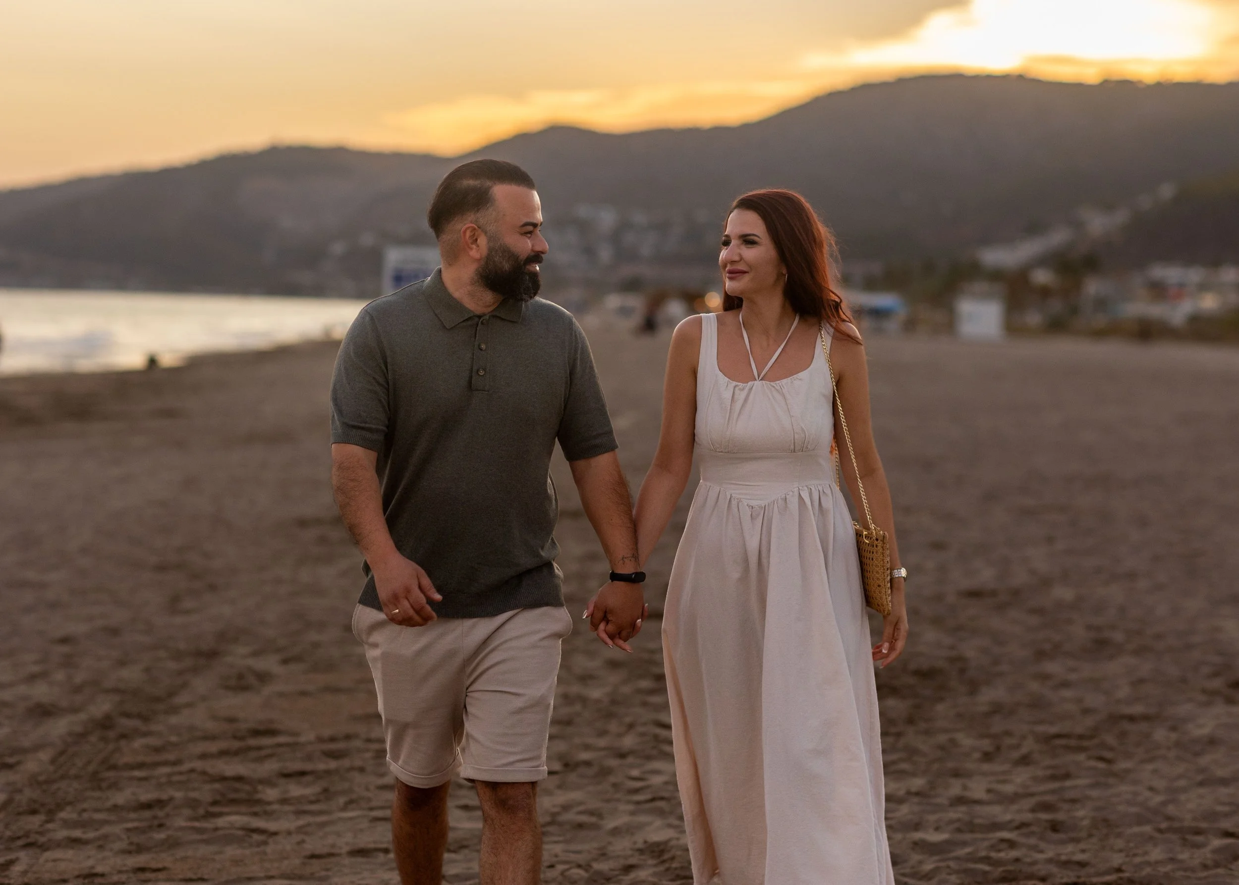 Emotional couple embracing after a surprise beach proposal near Barcelona at sunset