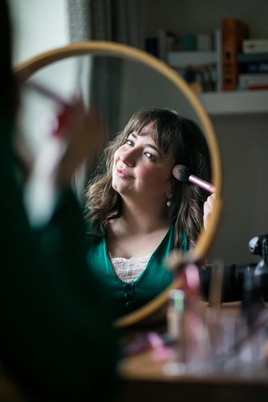 Woman applying makeup using a mirror