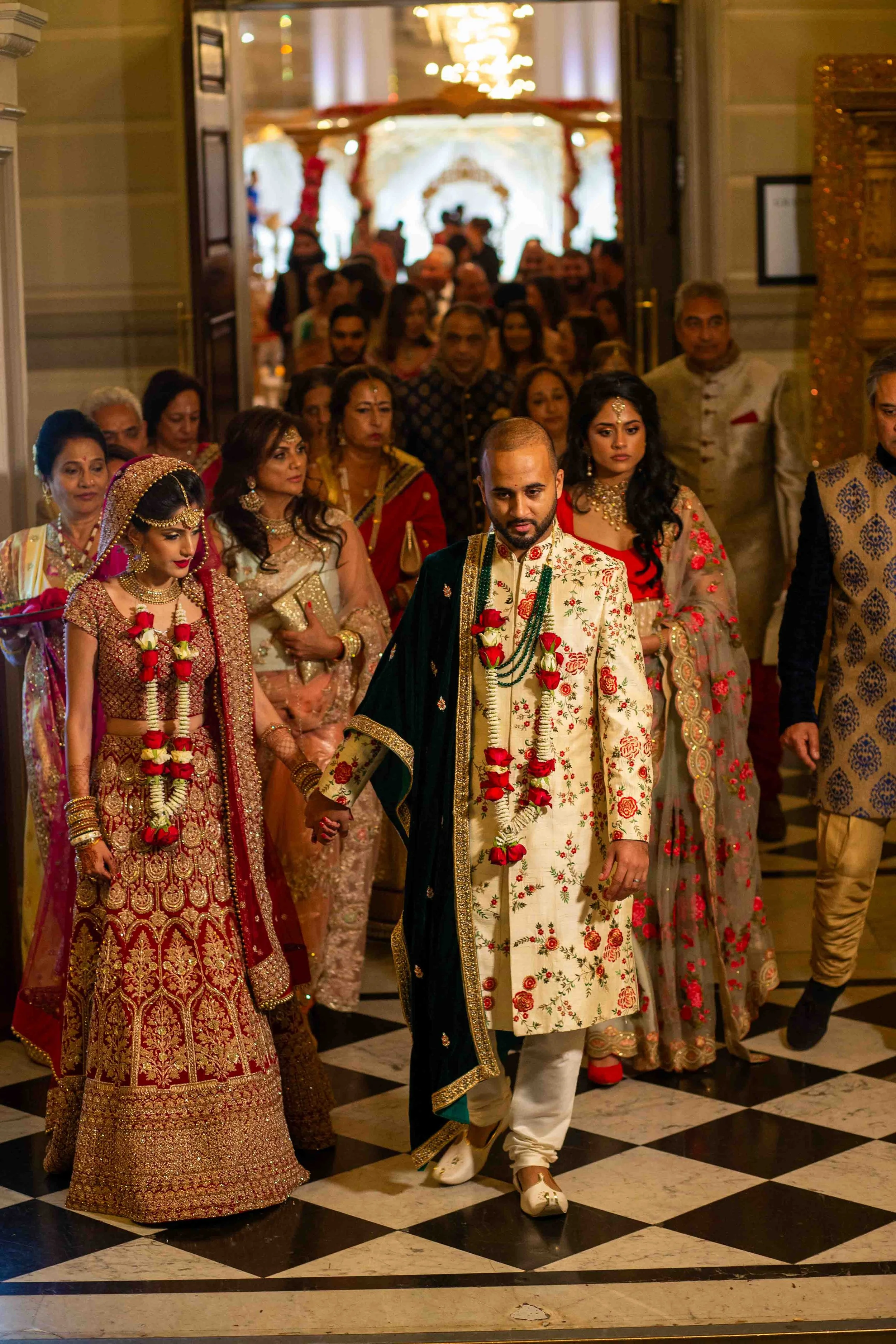 Indian wedding ceremony with bride and groom in traditional attire, surrounded by family and friends.