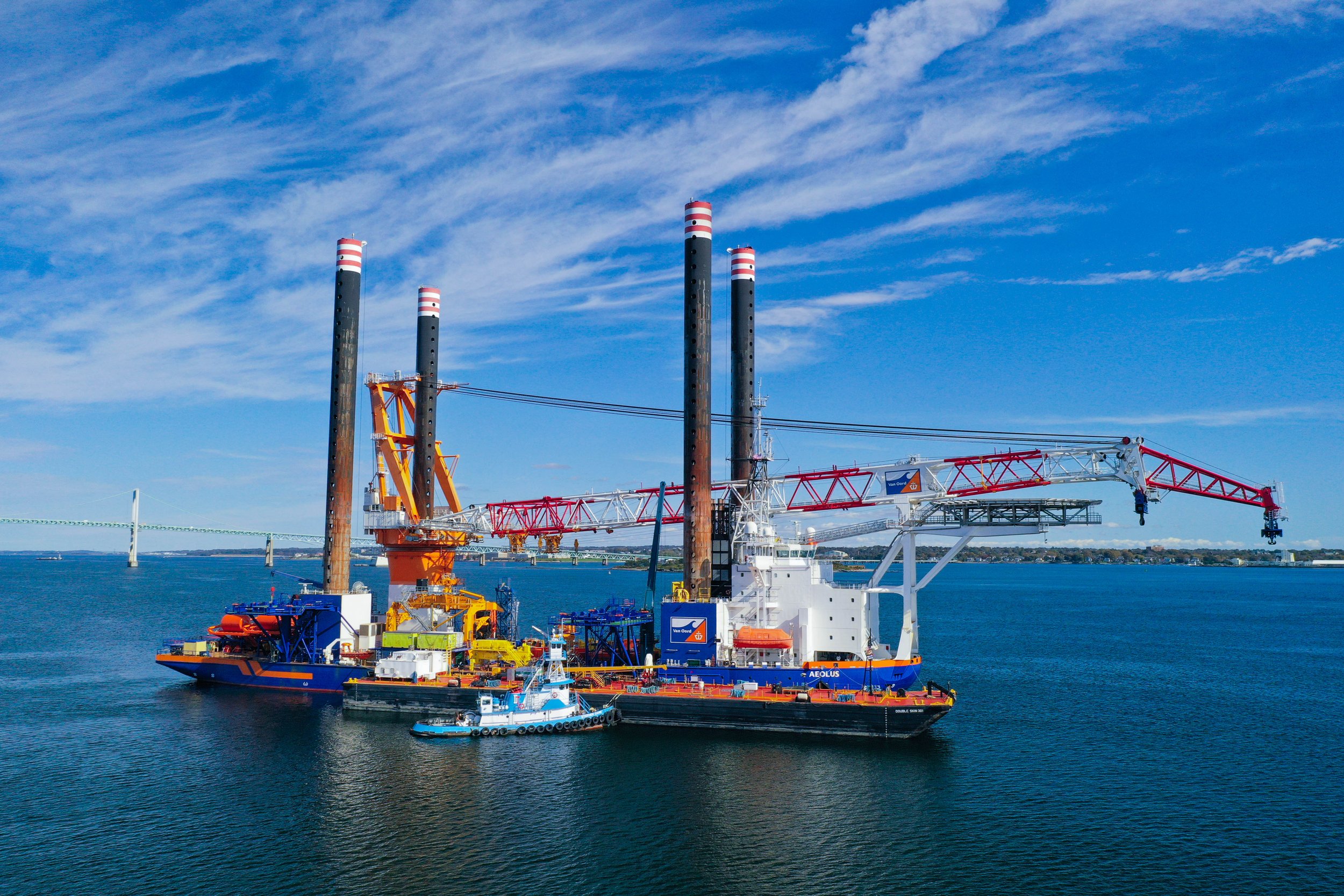 Offshore vessel with cranes and tugboat on the sea