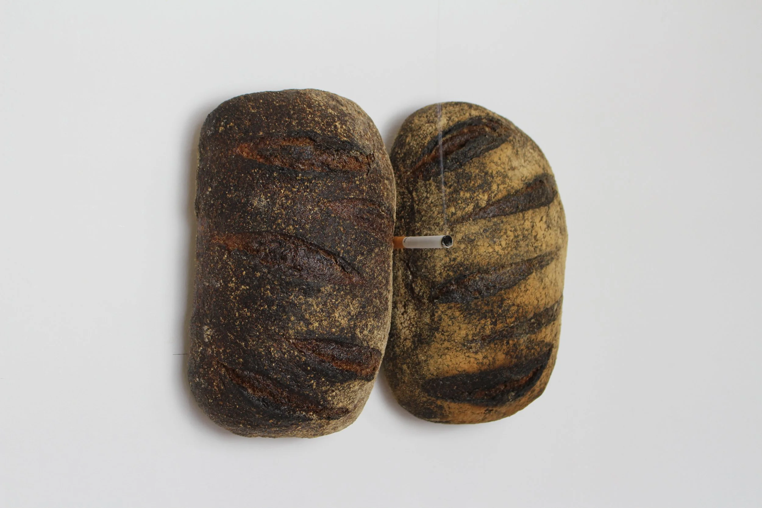 It All Ends Here, 2024. Bread loaves, cigarette — 30 x 20 x 8 cm
